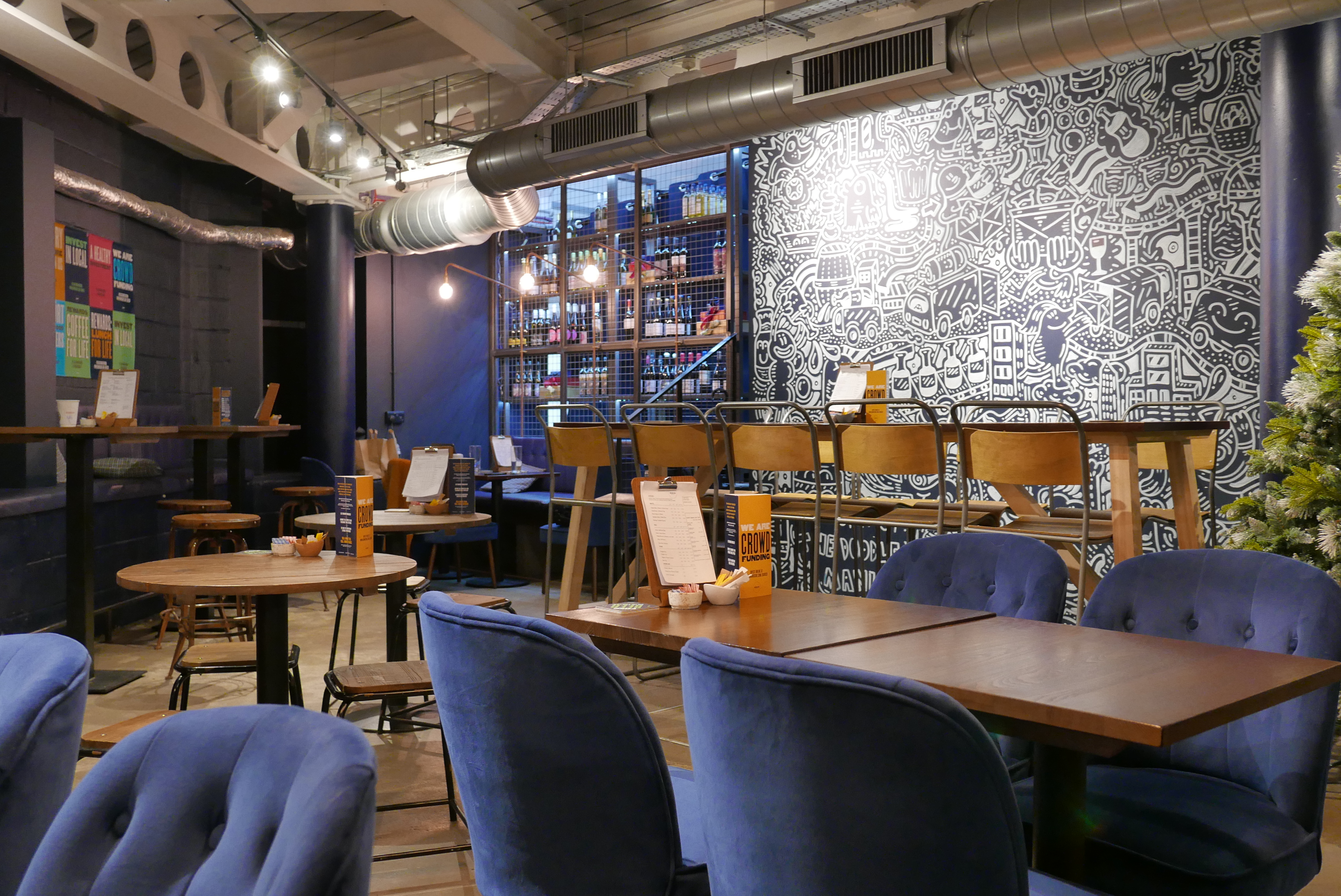Stylish event space in Sourced Market, Marylebone with cozy blue chairs and vibrant art.
