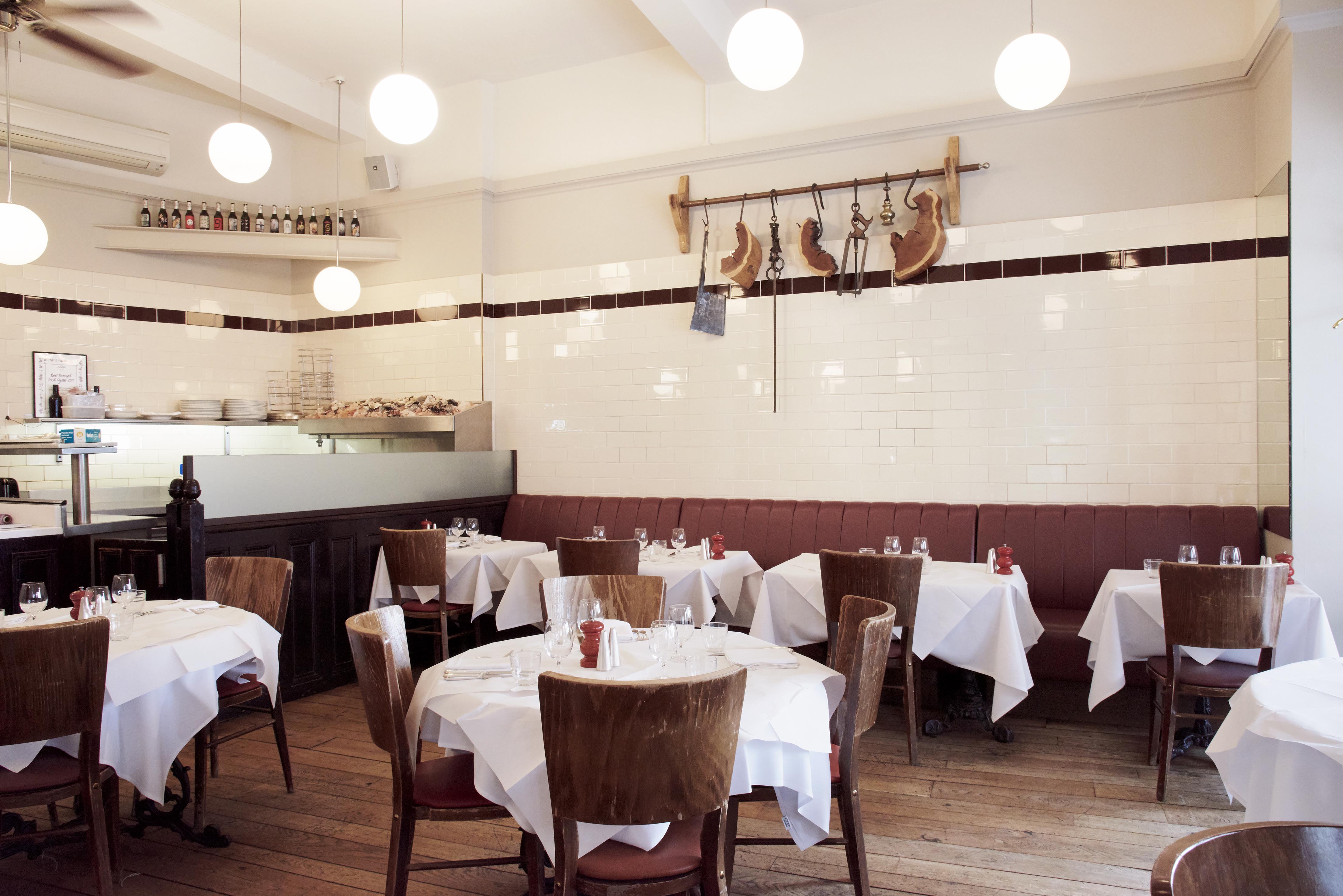 Charming HIX Oyster & Chop House restaurant with round tables for intimate events.