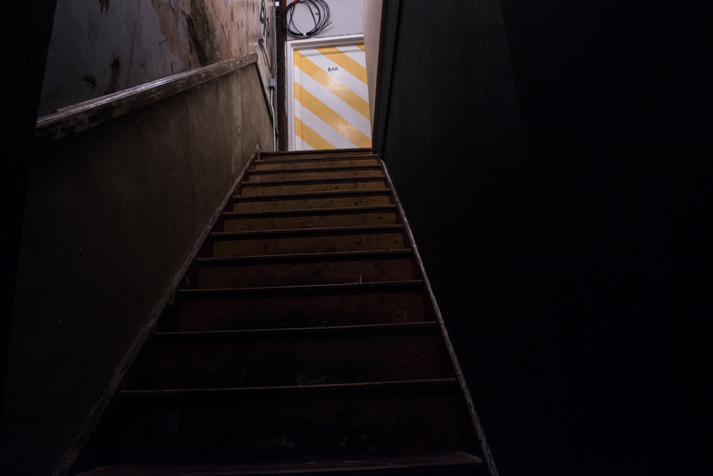 Dimly lit staircase at Fanny's Bar, ideal for unique events and safety considerations.
