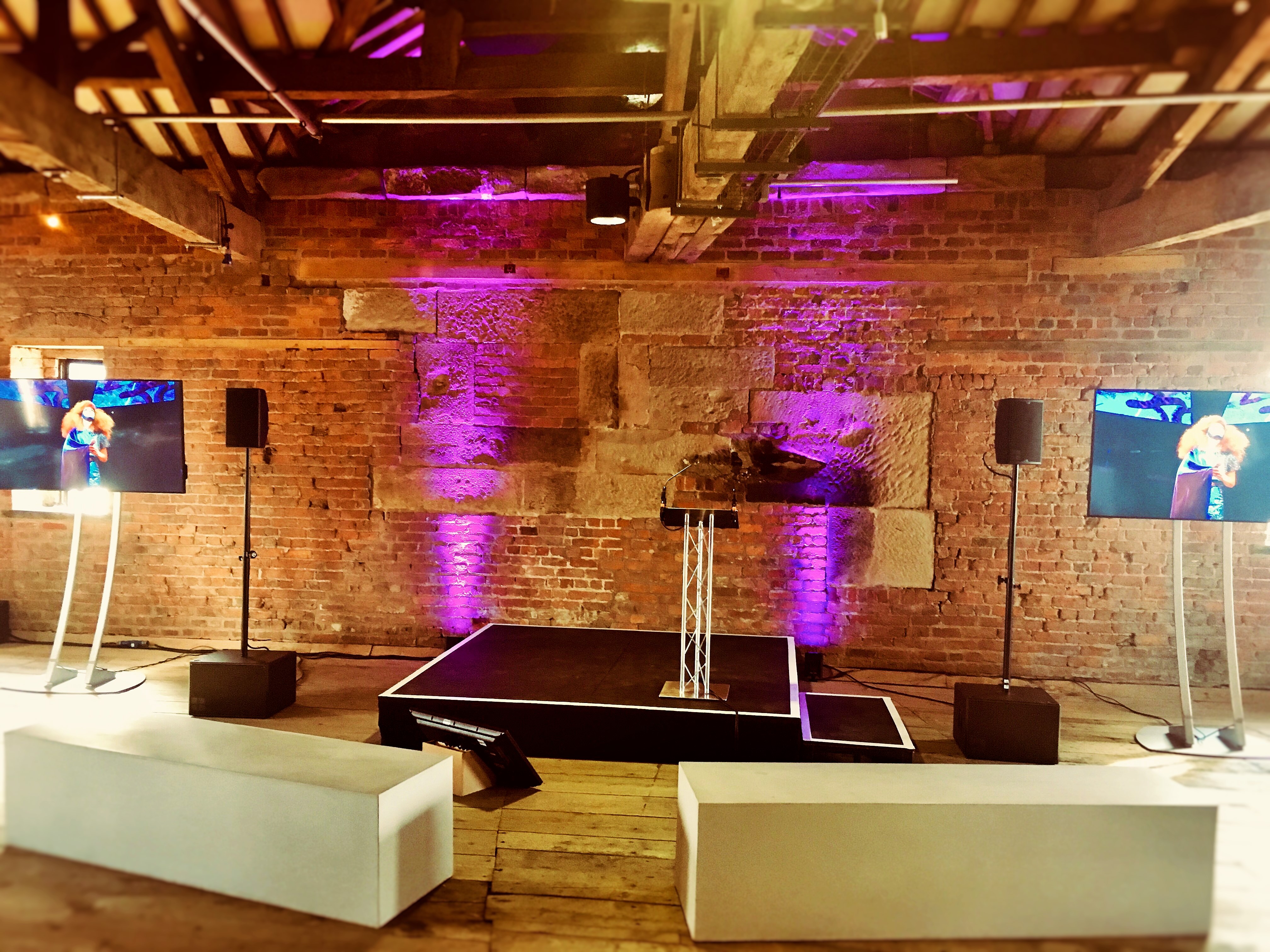 1830 Warehouse event space with stage, modern AV, ideal for conferences and corporate events.