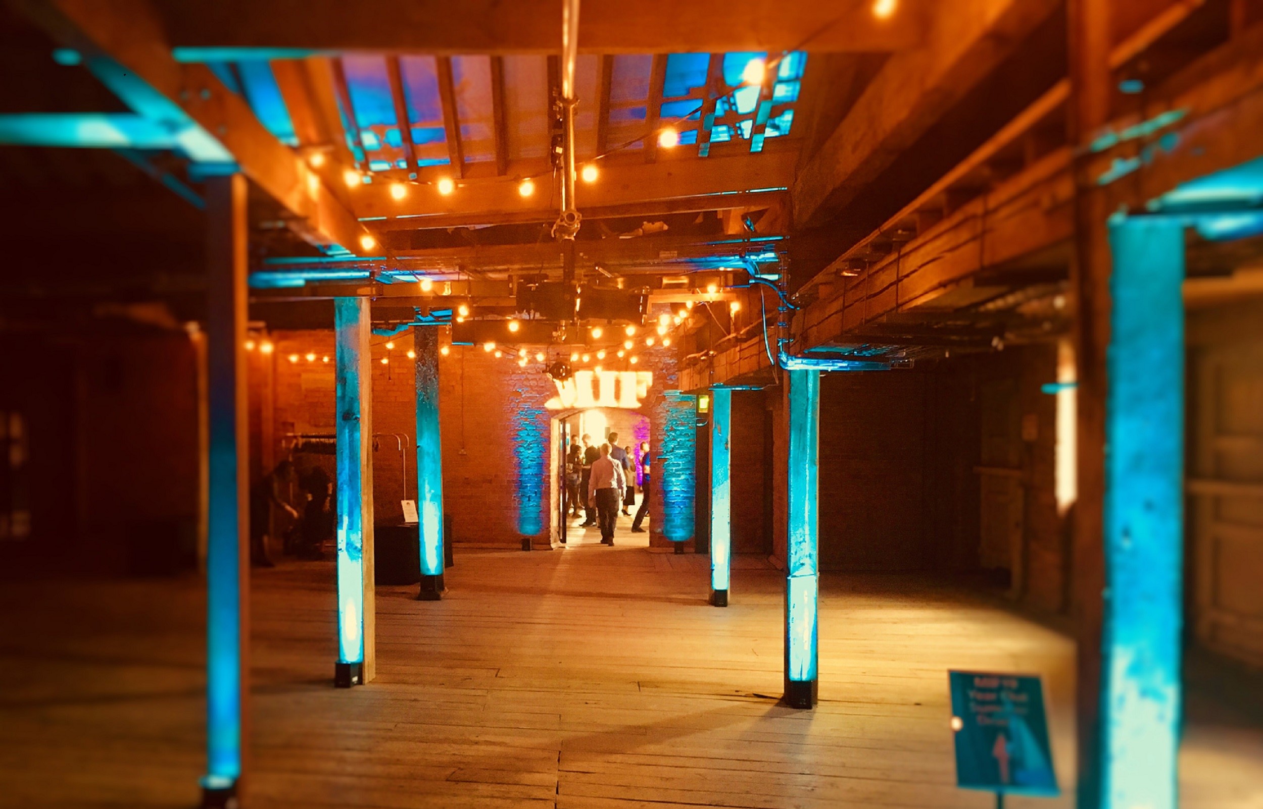 1830 Warehouse event venue with string lights, ideal for networking and social gatherings.
