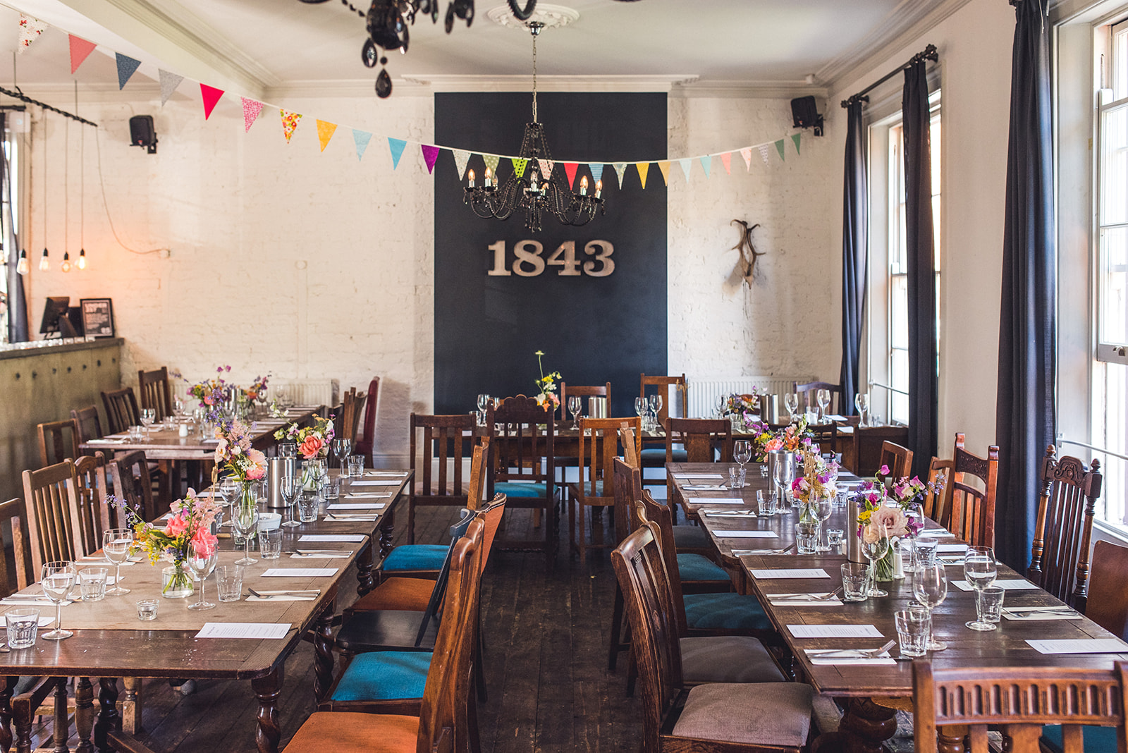 Charming event space at The Prince Albert Camden with rustic tables and floral decor.