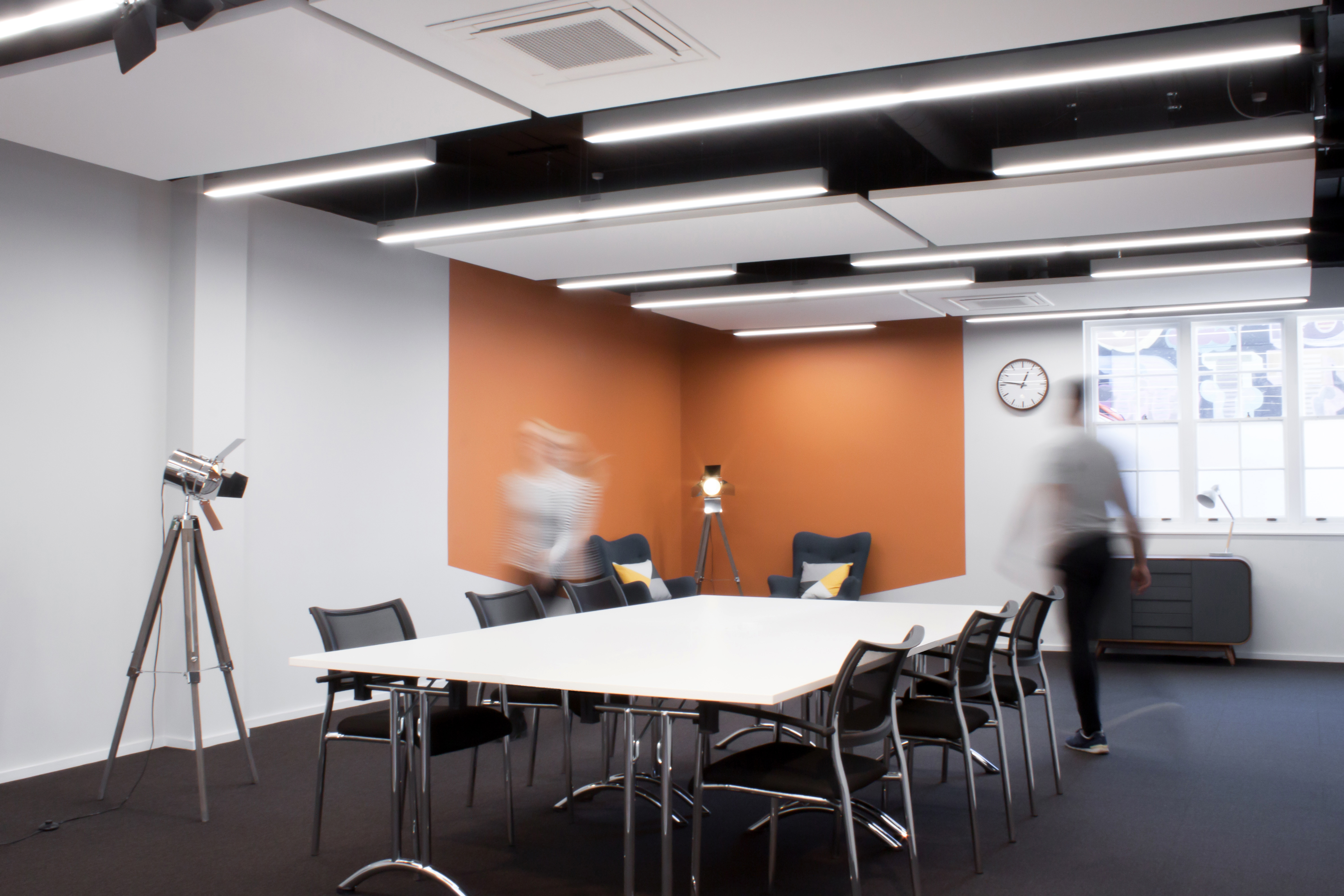 Modern meeting room with large table, ideal for hybrid meetings and presentations.