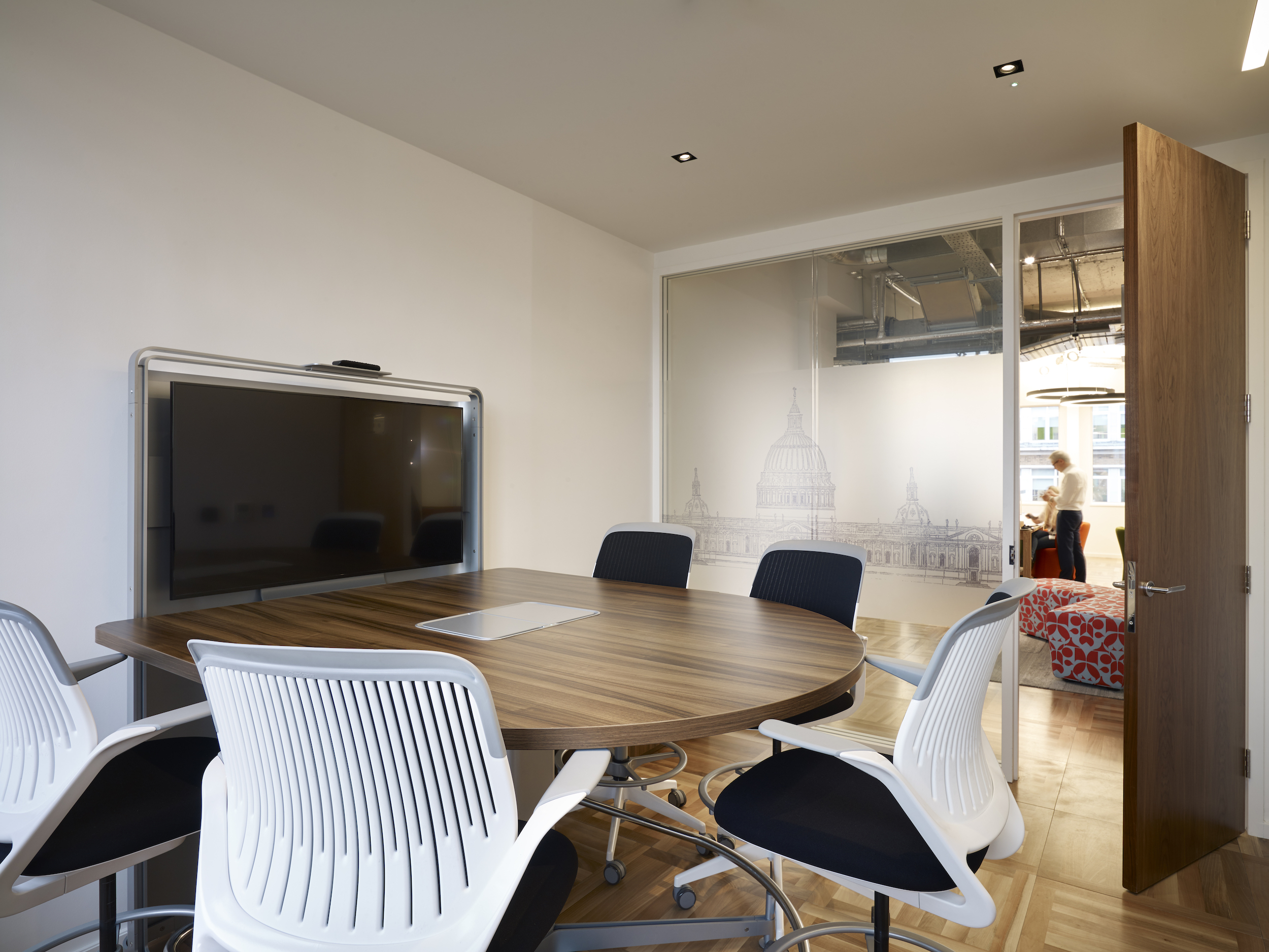 Modern meeting room with round wooden table for collaborative events at Us&Co Monument.