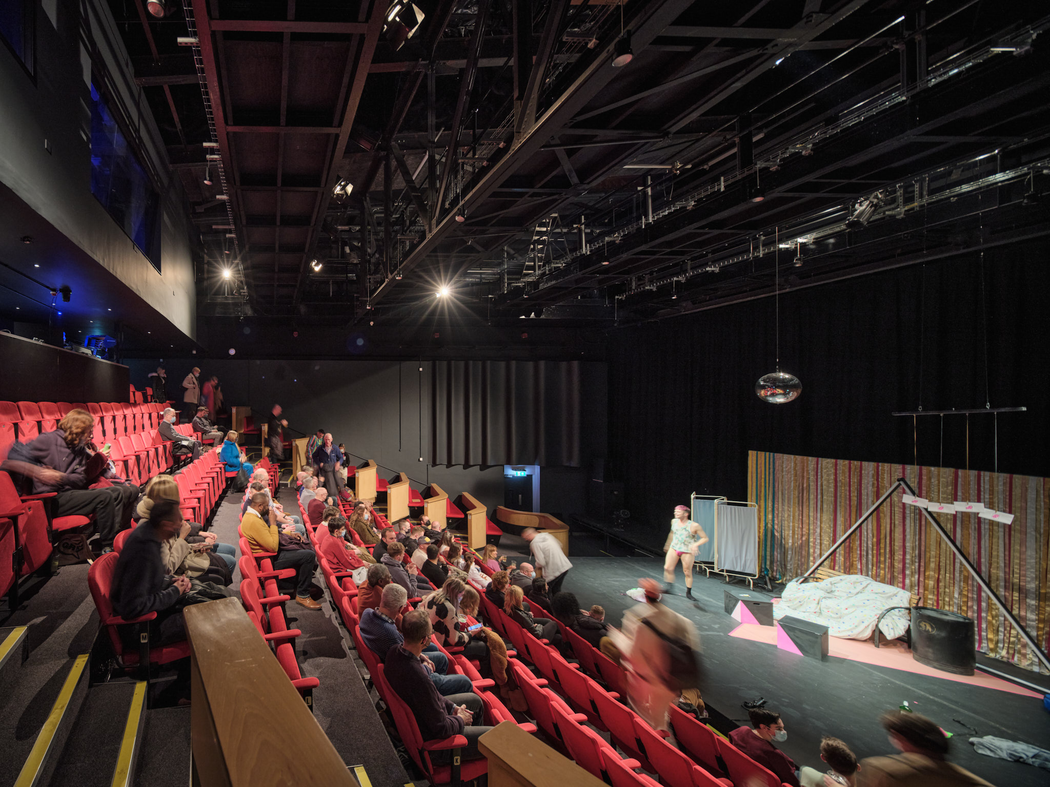 Theater setup with red seating for interactive performances at Contact Theatre.