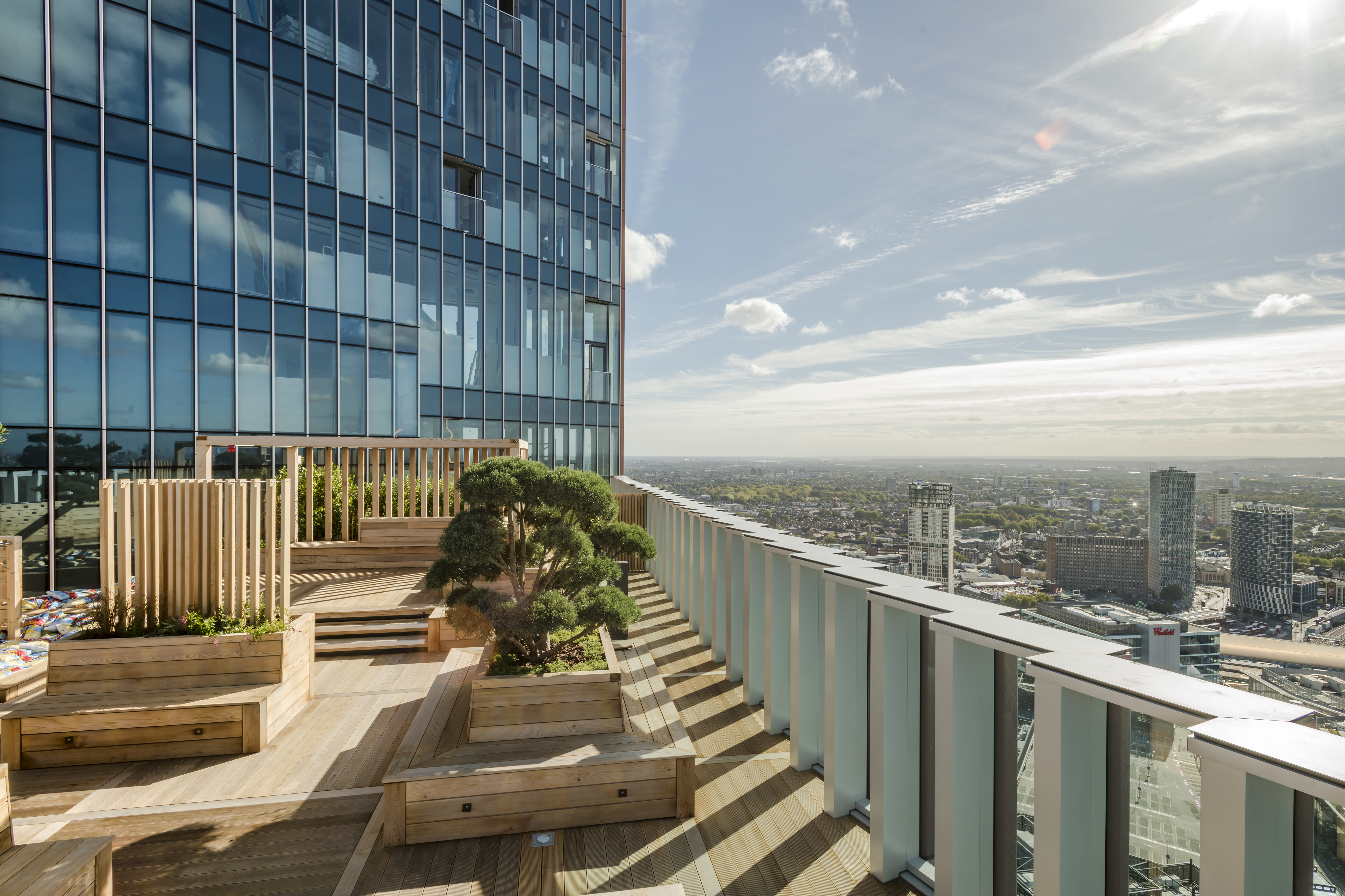 Rooftop terrace at The Stratford with wooden seating, ideal for outdoor events and gatherings.