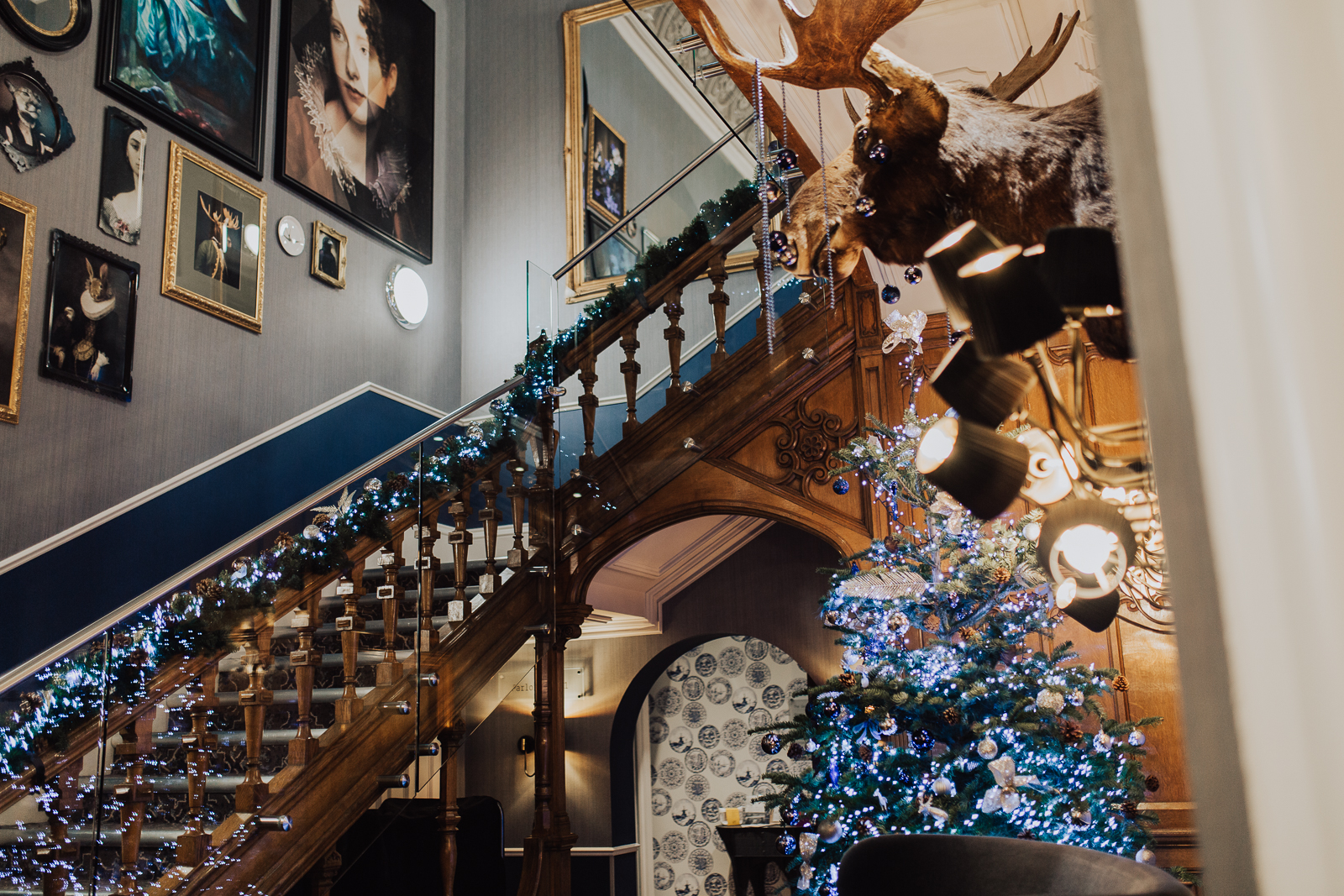 "Elegant staircase with festive lights at Oddfellows On The Park for holiday events."