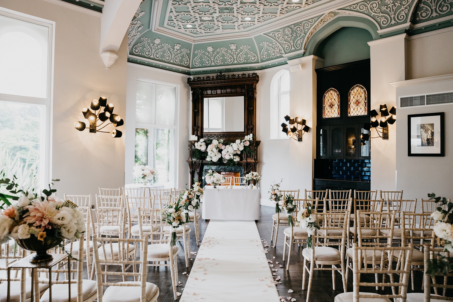 Elegant wedding ceremony setup with gold chiavari chairs and floral aisle at Oddfellows On The Park.