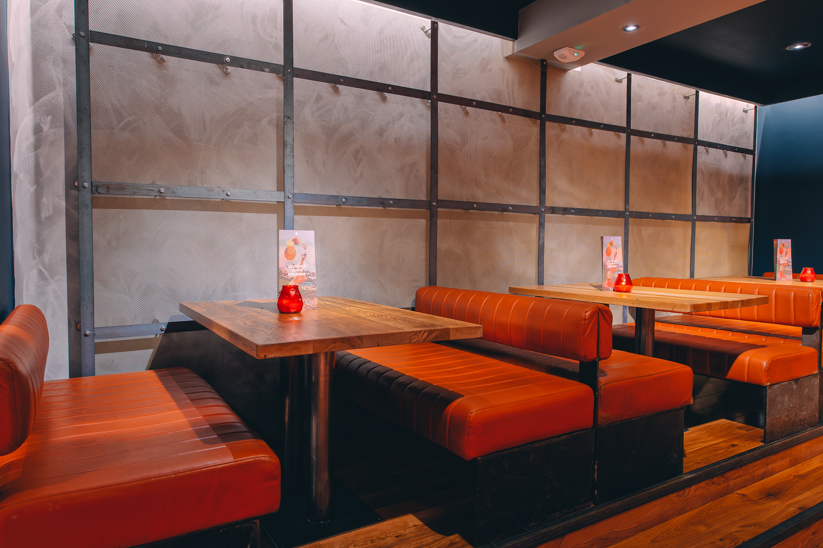Modern dining space at Skye Bar, Glasgow with orange seating for networking events.