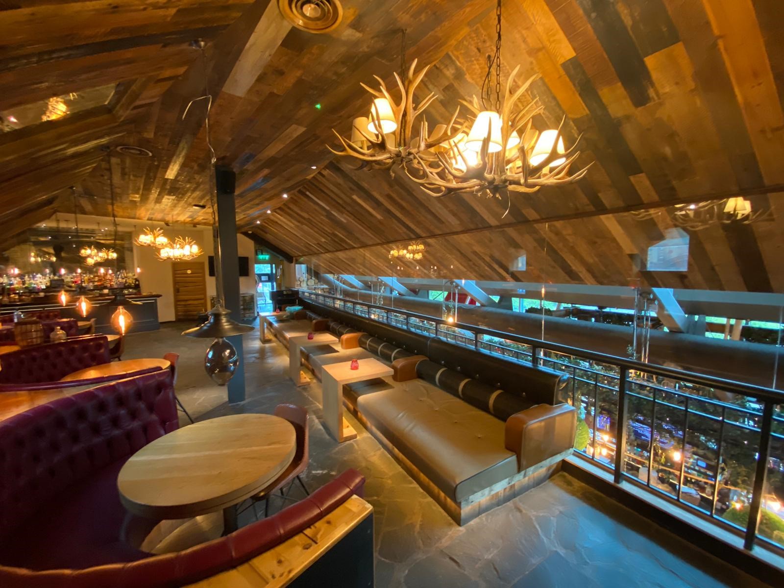 Stylish event space at Impossible Bar with rustic beams, perfect for networking and gatherings.