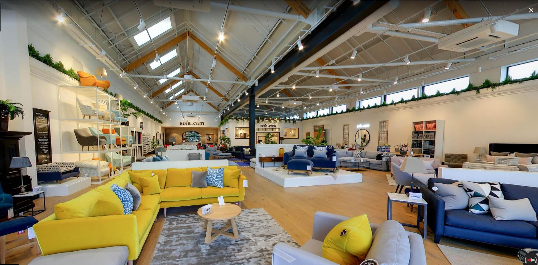 Spacious Sofa.com Harrogate showroom with yellow sofa, ideal for events and meetings.