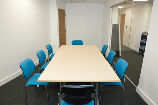 Modern meeting room at Grove Vale Library with blue chairs, ideal for presentations.
