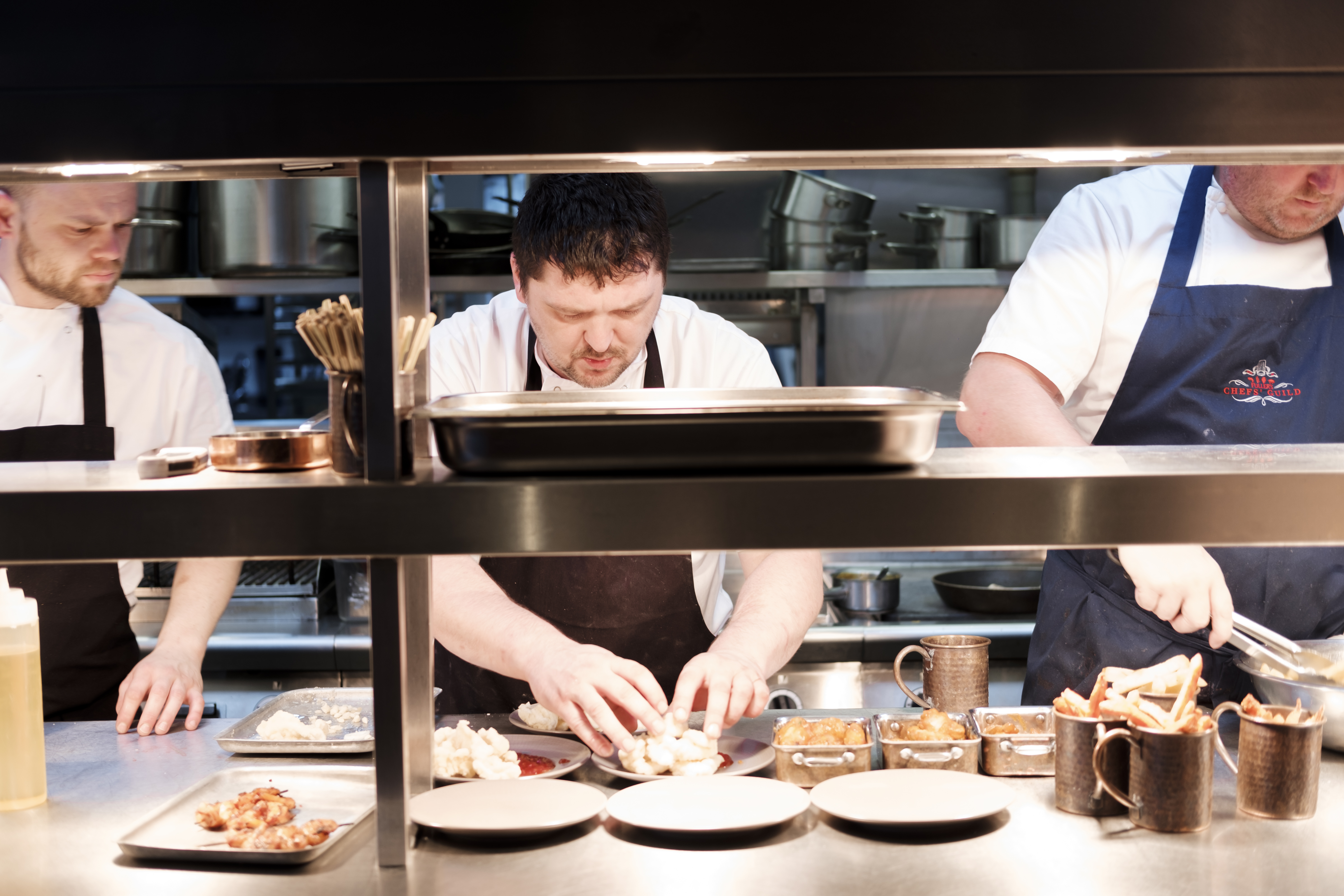 Chefs in a busy kitchen at The Container, showcasing event catering teamwork and precision.