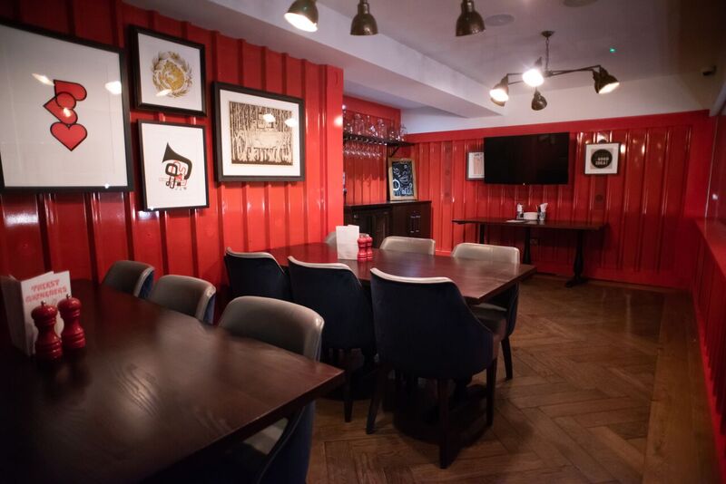 Vibrant meeting space with red walls, ideal for gatherings and presentations.