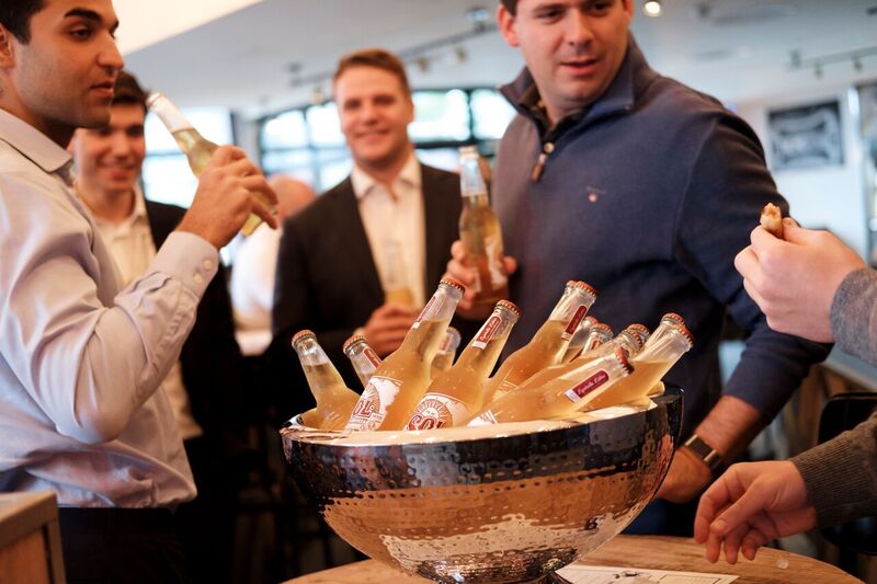 Lively networking event at The Snug with refreshments and ice bucket for mingling.