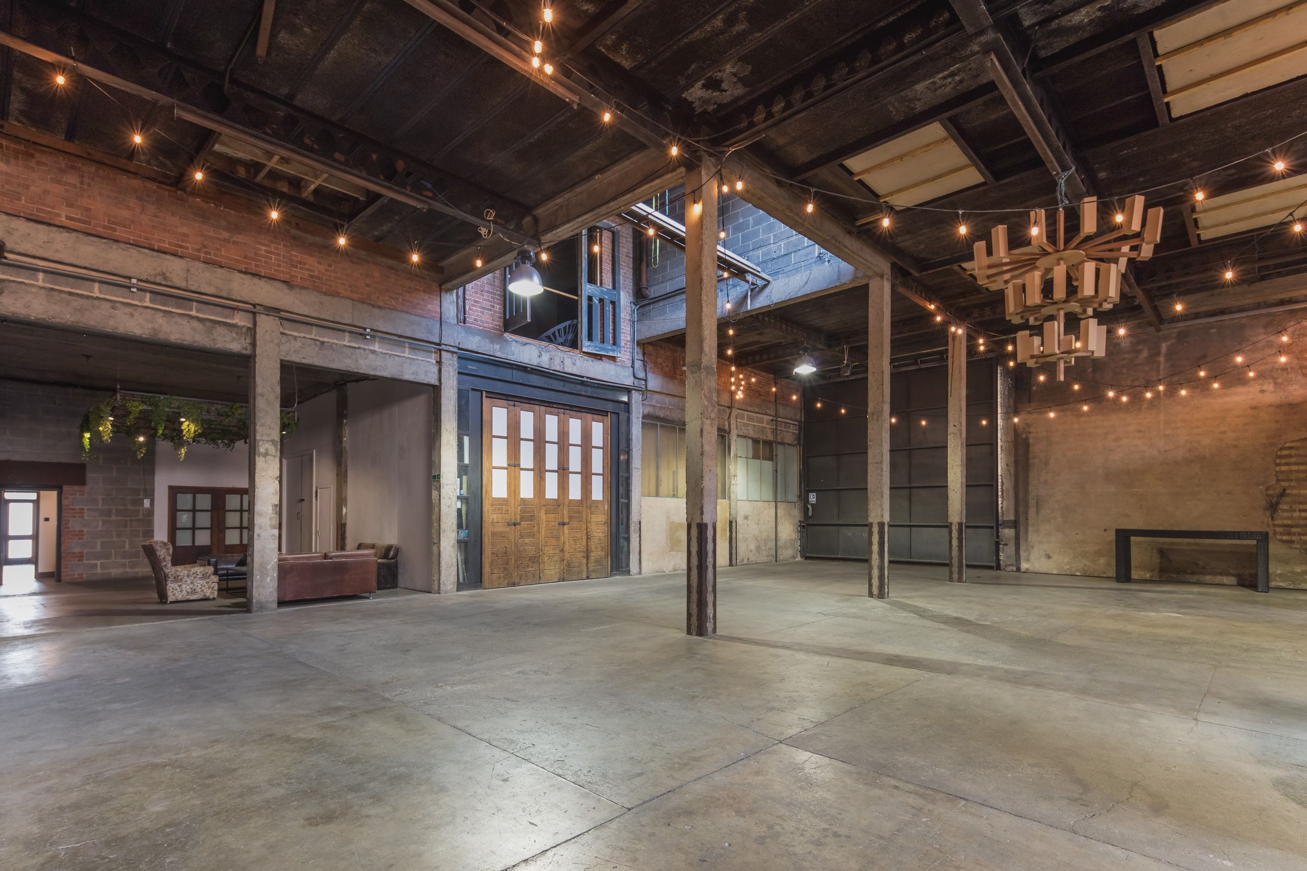 Versatile event space in Hoxton Docks with exposed brick and string lights for weddings.