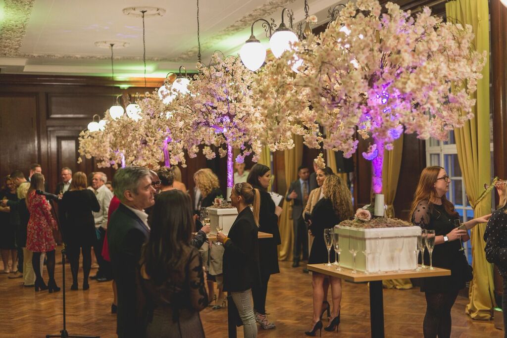 Elegant event space with cherry blossom trees, ideal for networking and social gatherings.