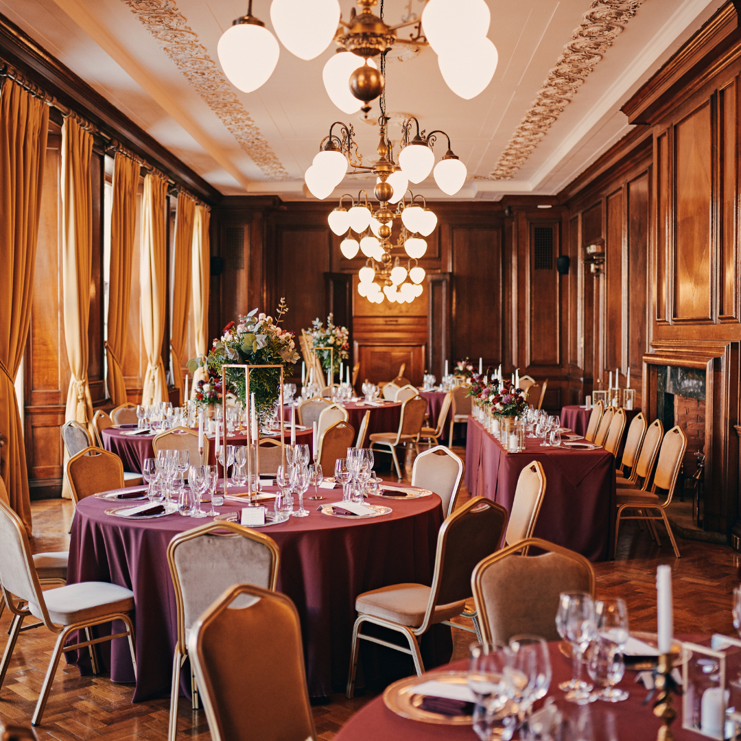 Elegant event space in Manchester Hall with burgundy tables, ideal for receptions and gatherings.