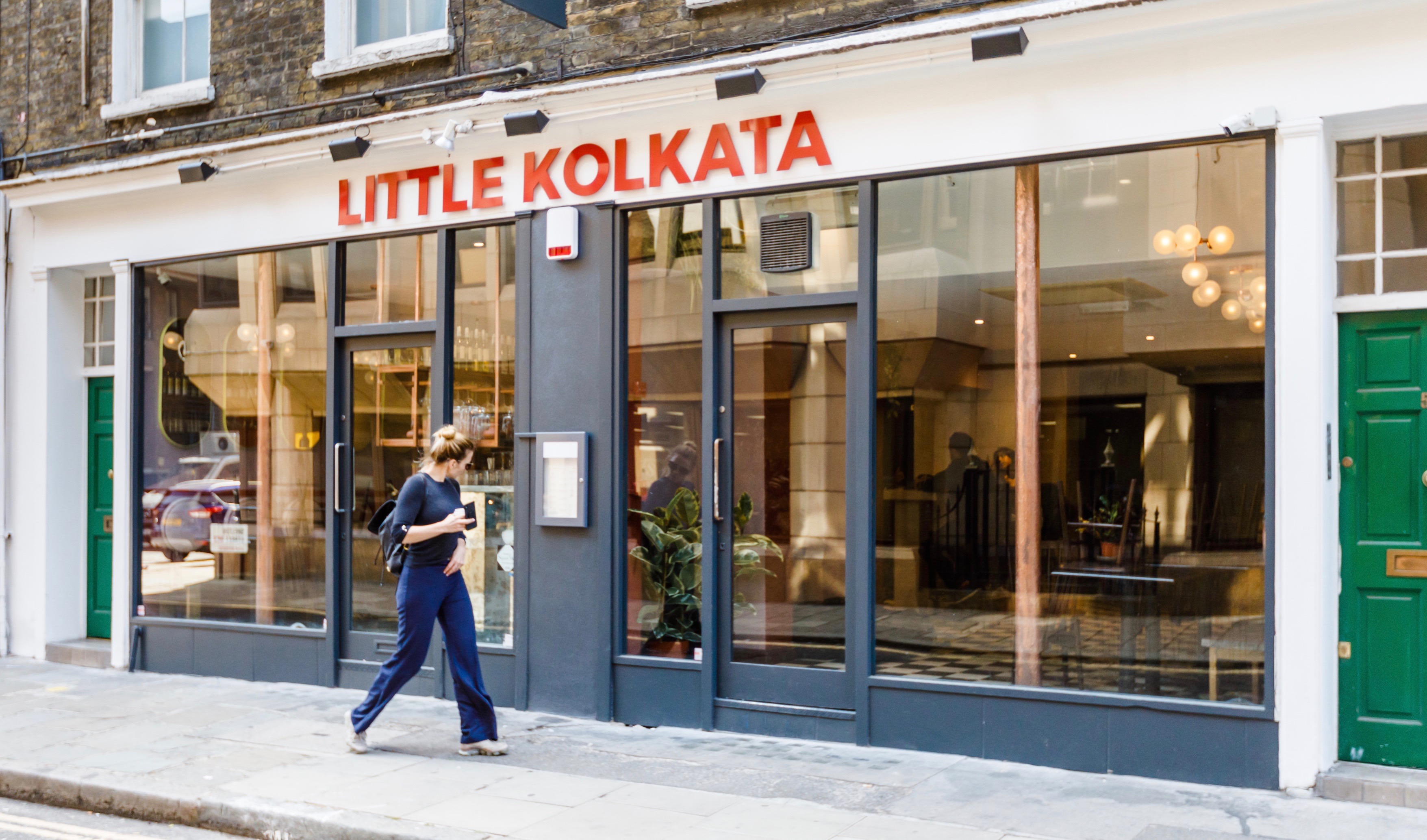 Contemporary event venue "Little Kolkata" with large windows, perfect for receptions and meetings.