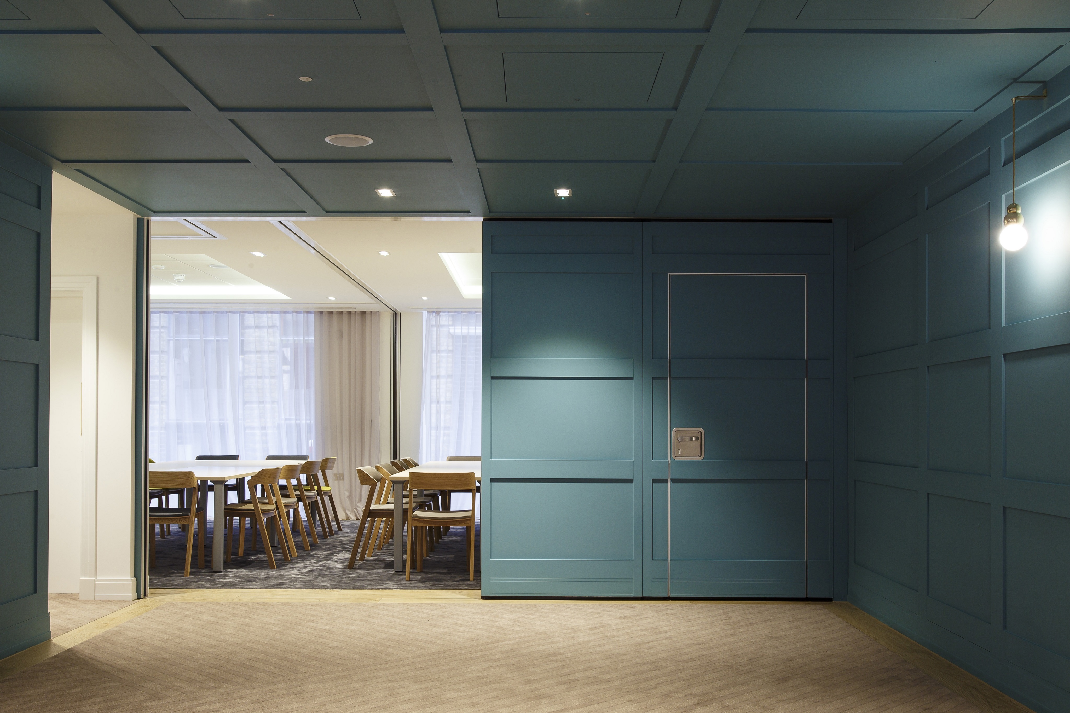 Modern meeting space with blue paneling, ideal for workshops and corporate events.