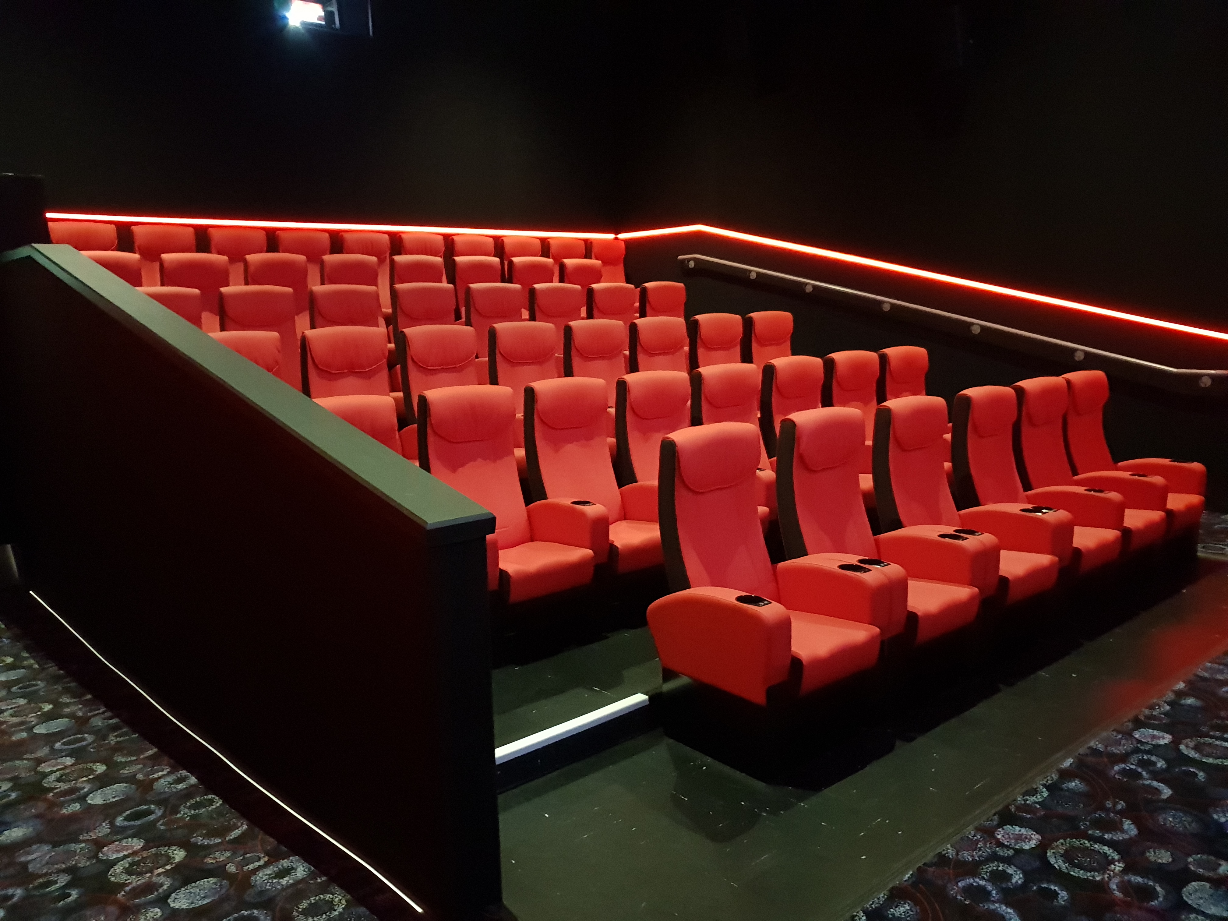 Cineworld Watford Screen 7 with red tiered seating for corporate events and screenings.