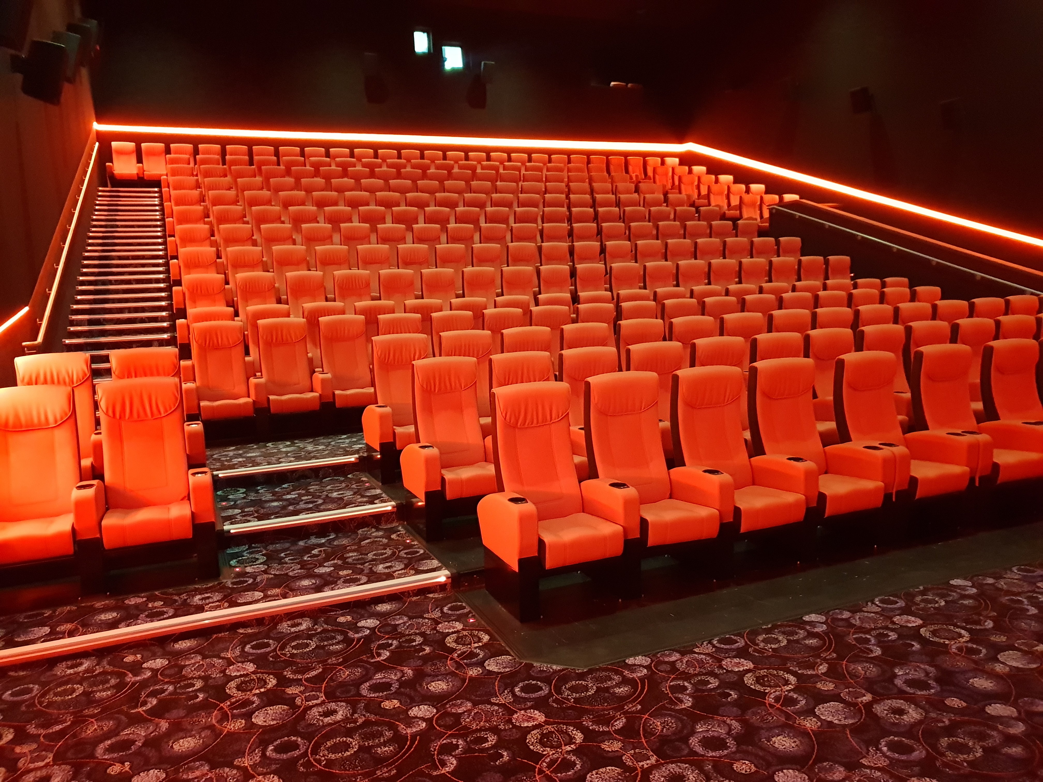 Modern cinema auditorium with orange seating, ideal for film screenings and private events.
