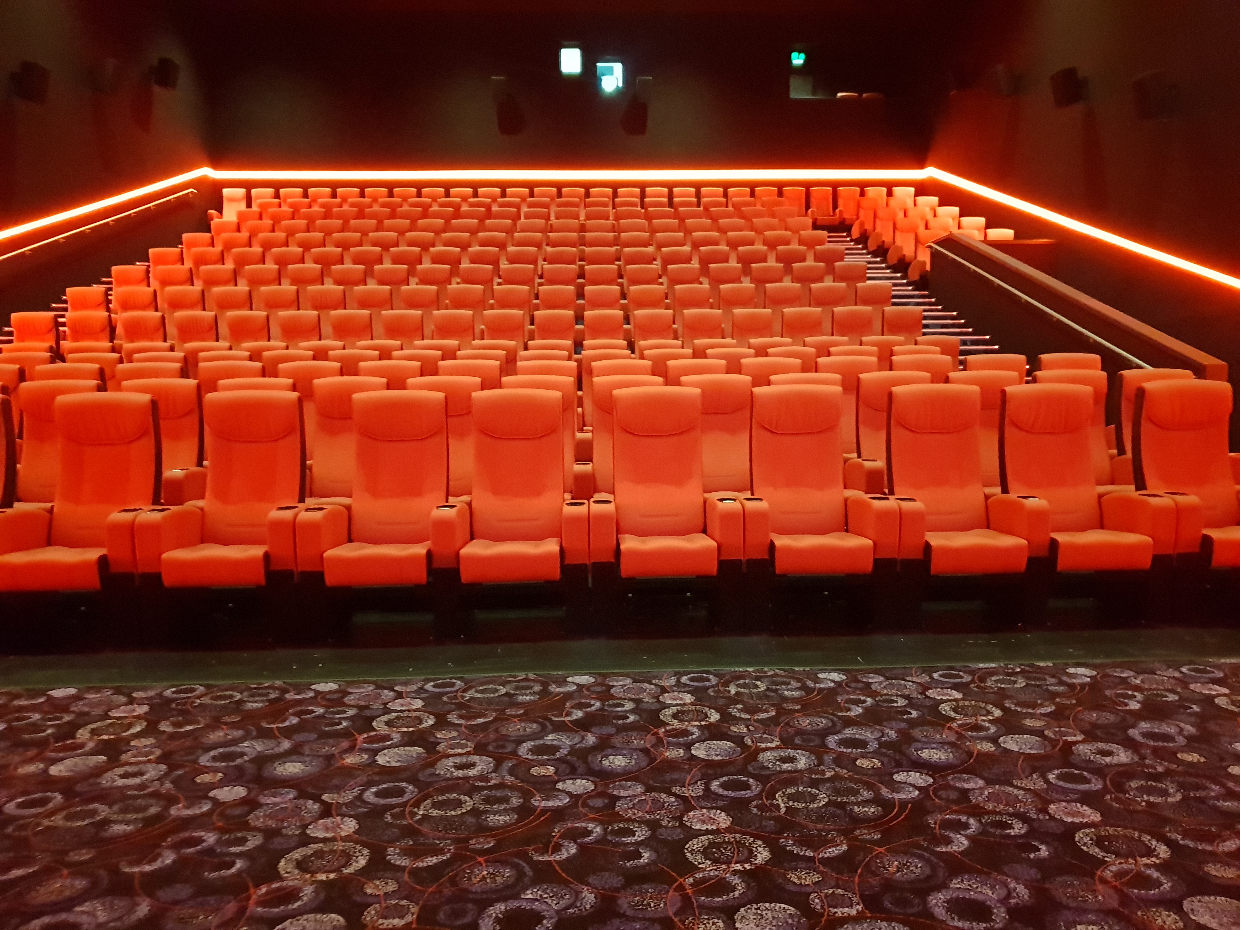 Modern cinema auditorium with orange seating, ideal for film screenings and corporate events.