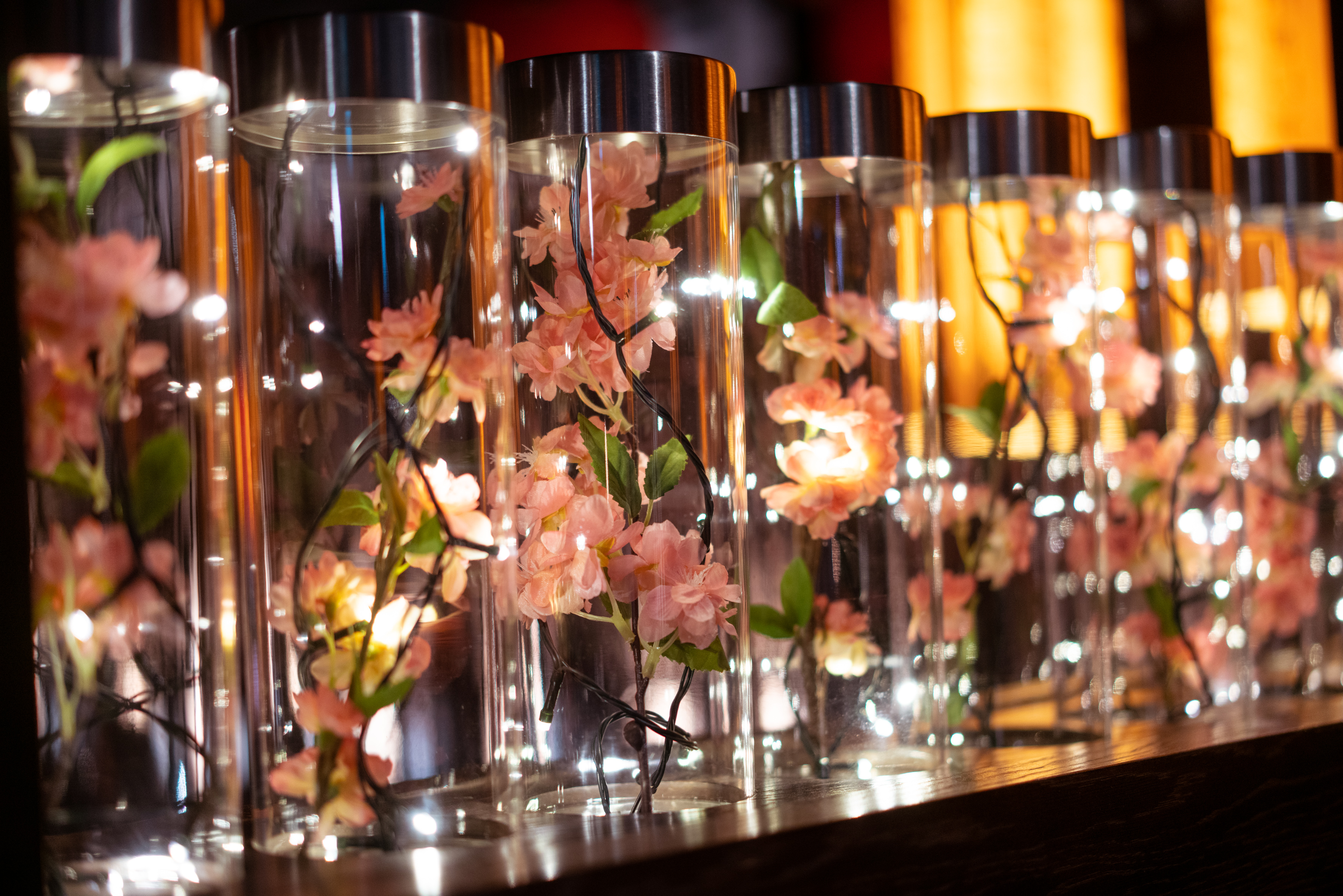 Elegant bar area with illuminated vases and flowers, perfect for event decor.