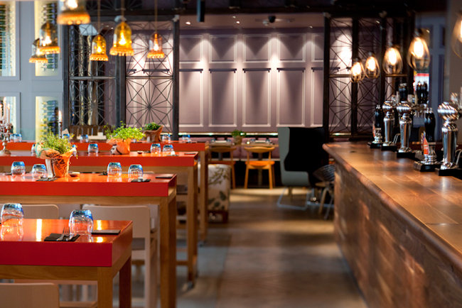 Modern restaurant venue with vibrant red tables, perfect for events and gatherings.