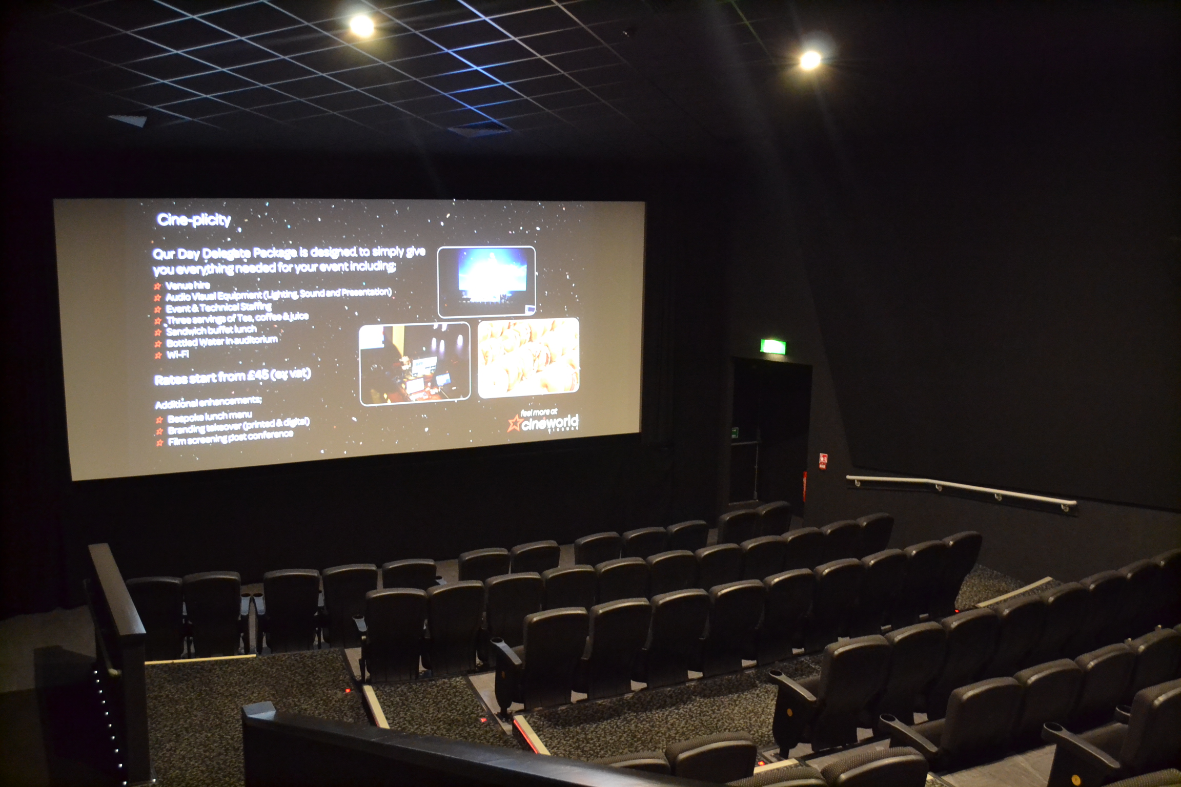 Modern event space with large screen and tiered seating for corporate meetings.