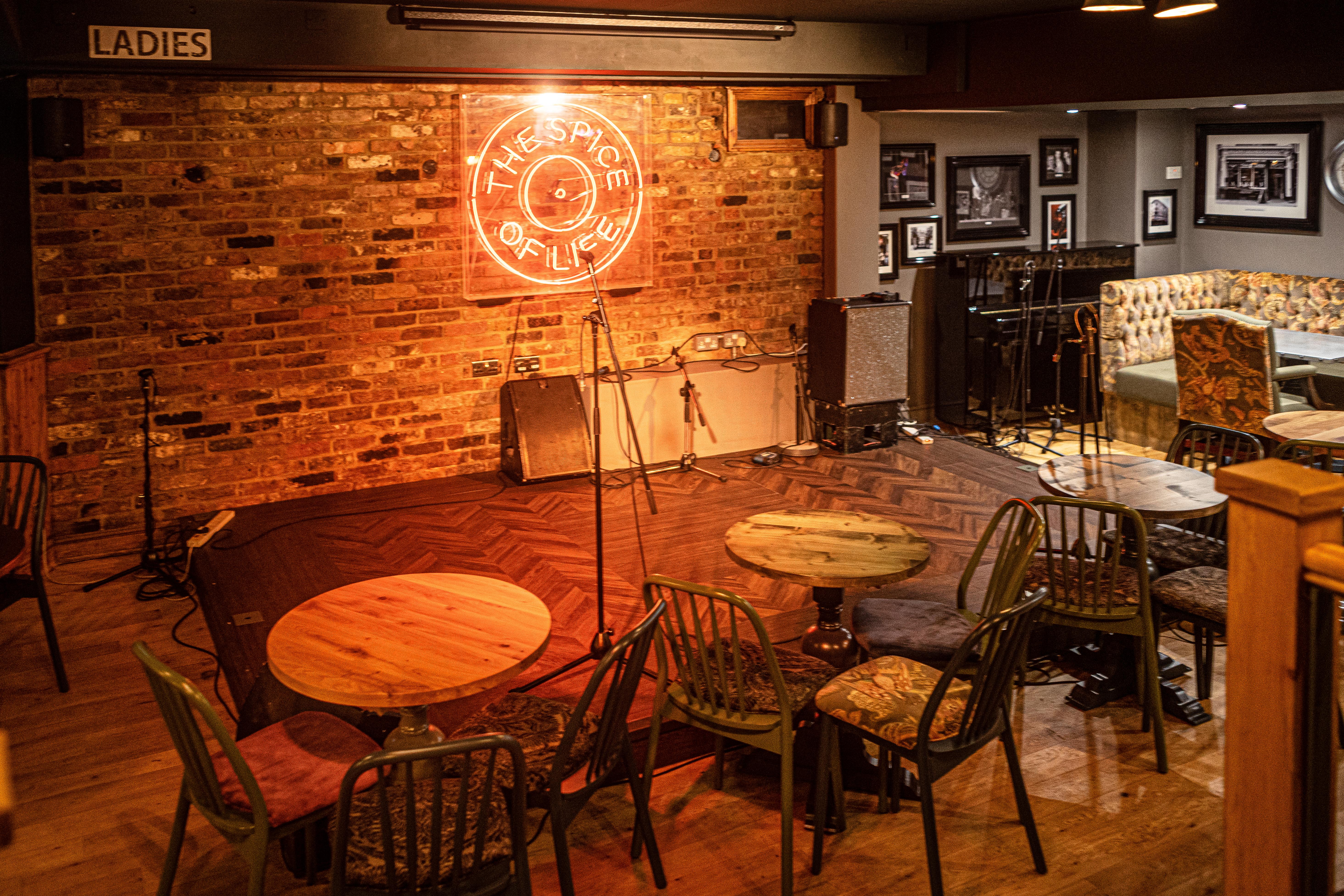 Cozy Backstage Basement venue with warm lighting for live performances and gatherings.