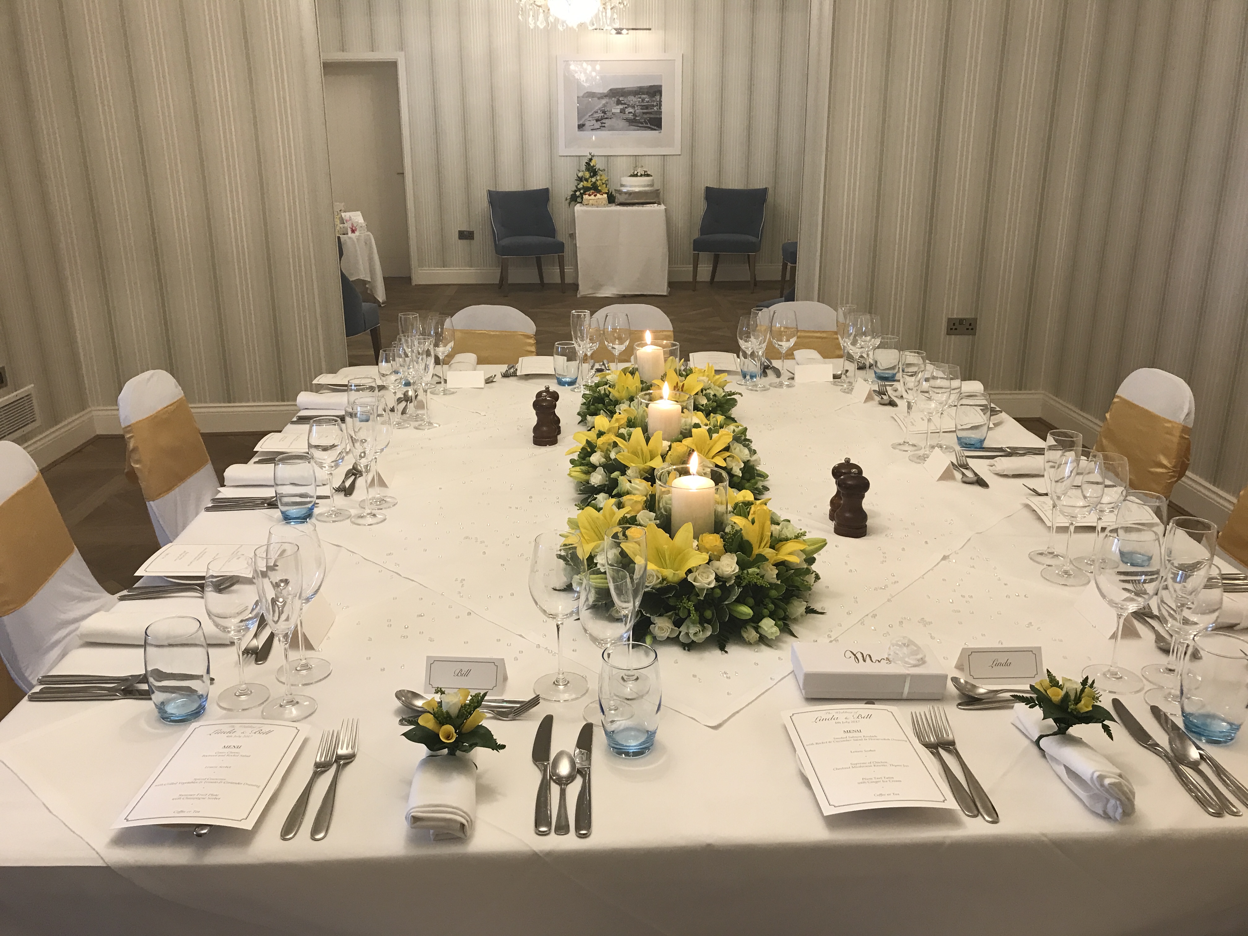 Elegant banquet table in Harbour Suite, Sidmouth with yellow flower centerpiece.