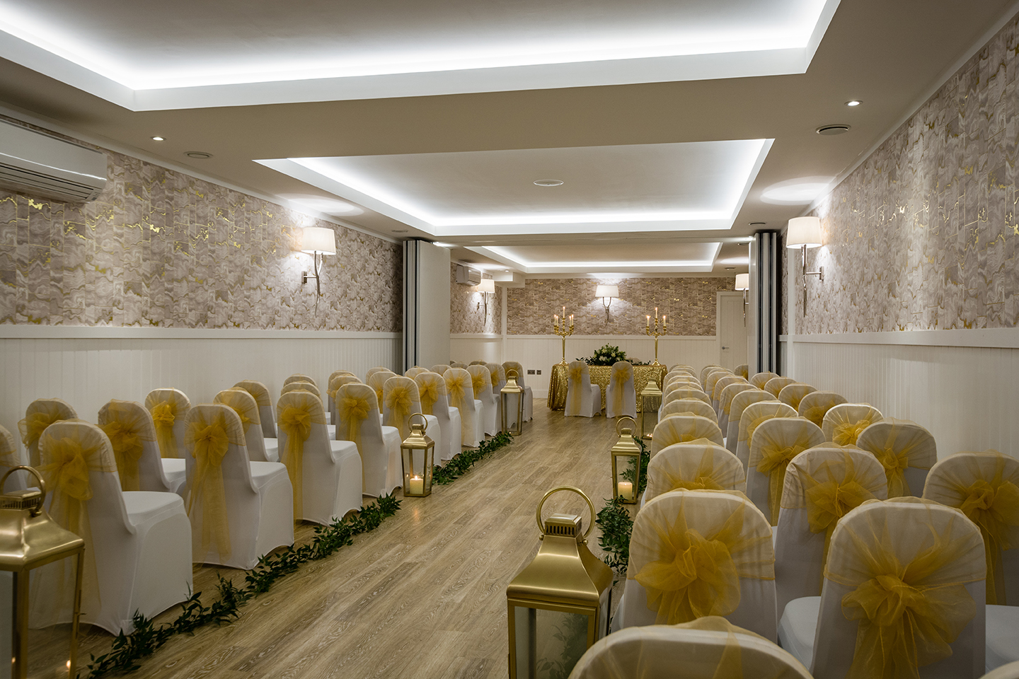 Elegant event space at The Vaults, Bristol with white chairs and yellow sashes for weddings.