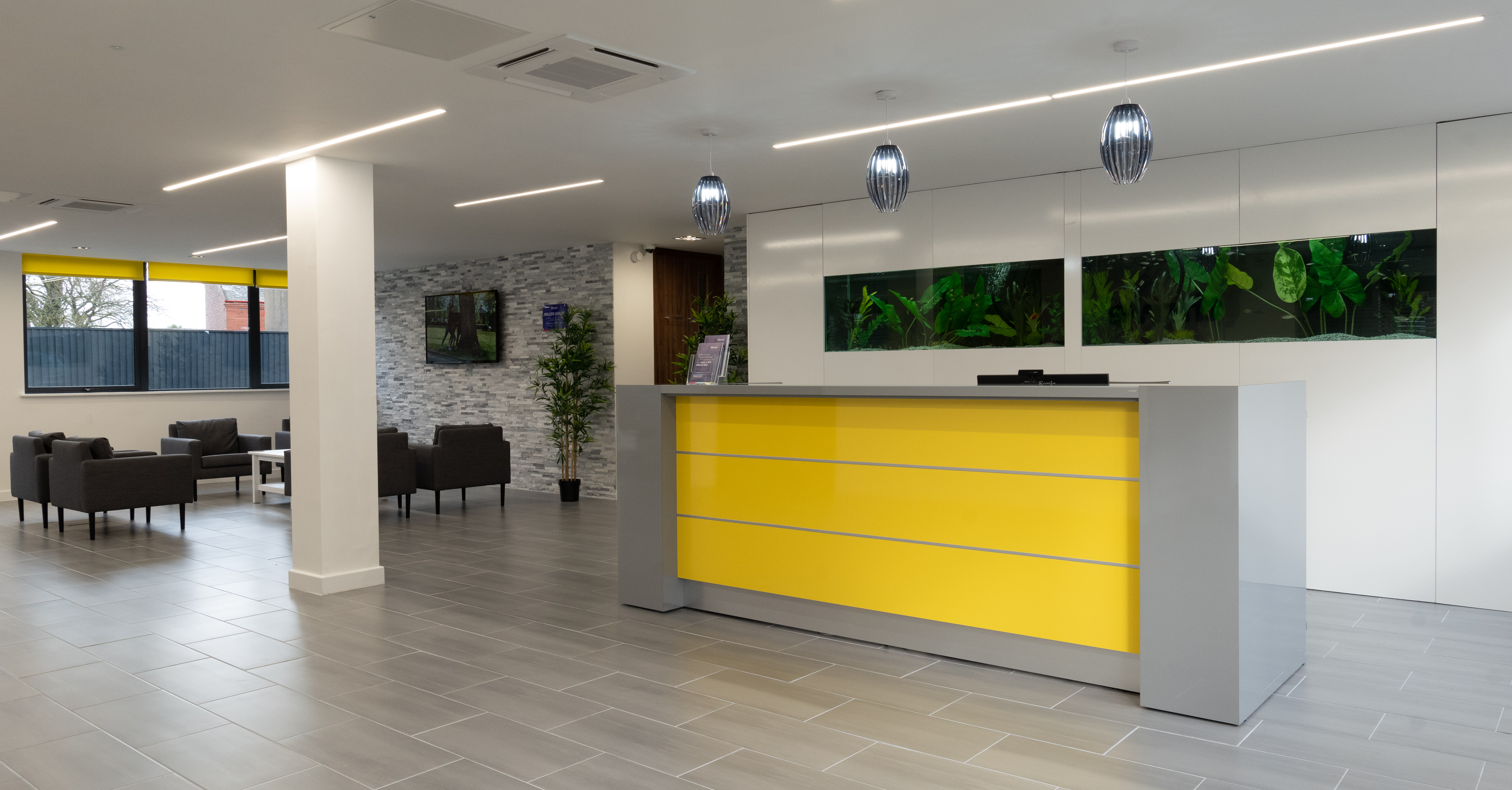Modern meeting room with yellow reception desk, ideal for events and networking.