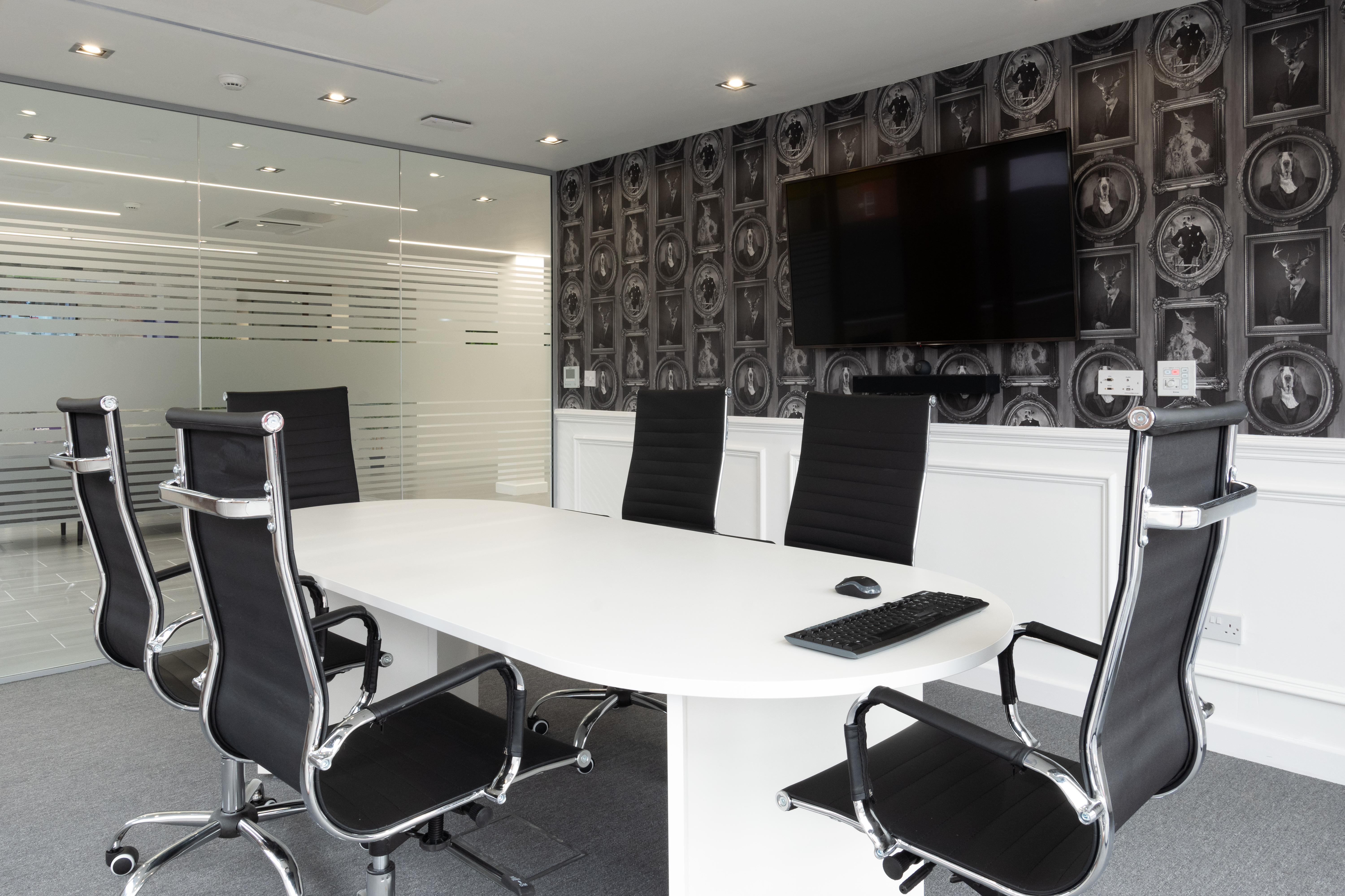Modern conference room with oval table, ideal for meetings and presentations.
