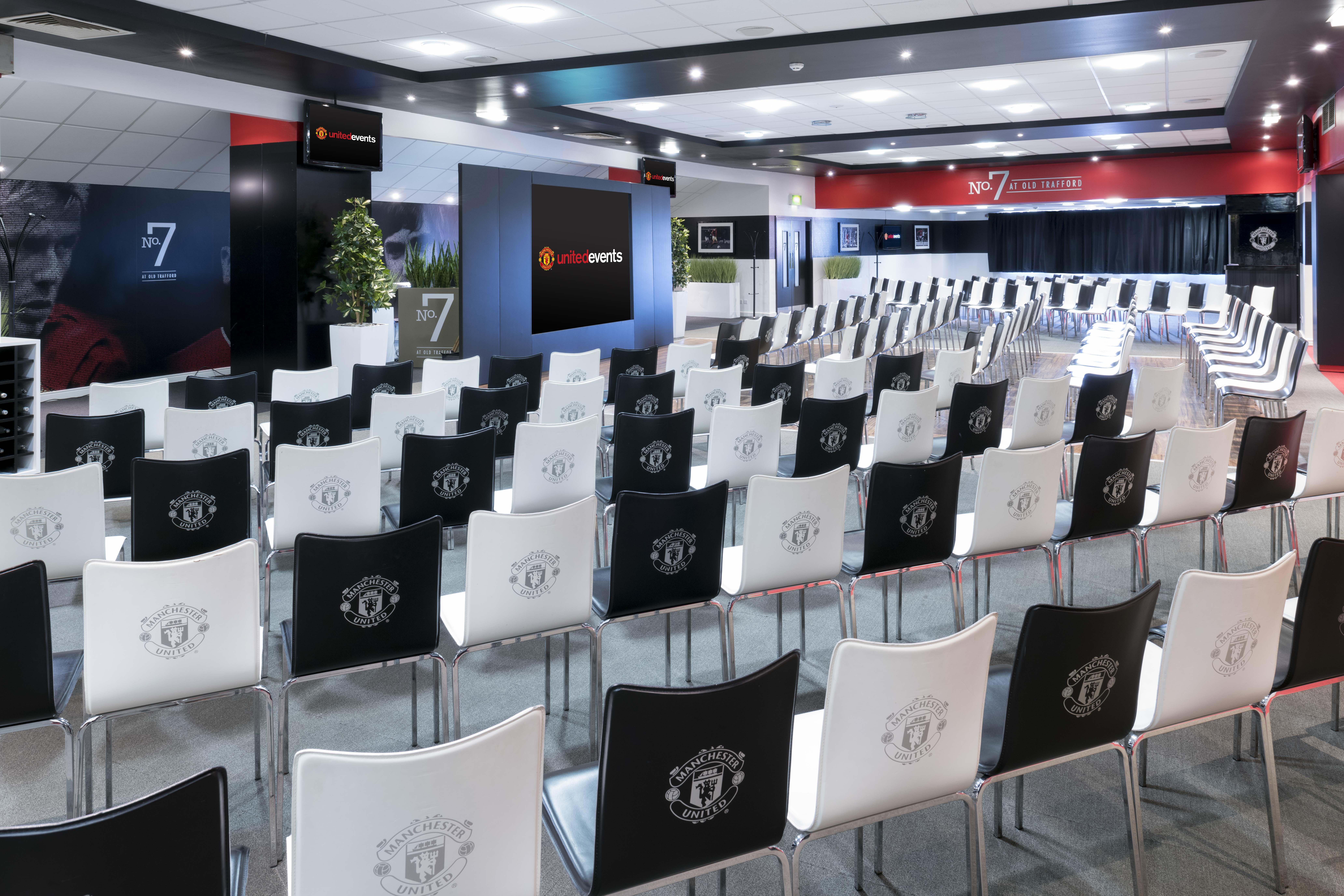 Conference event space at Old Trafford with branded chairs for presentations.