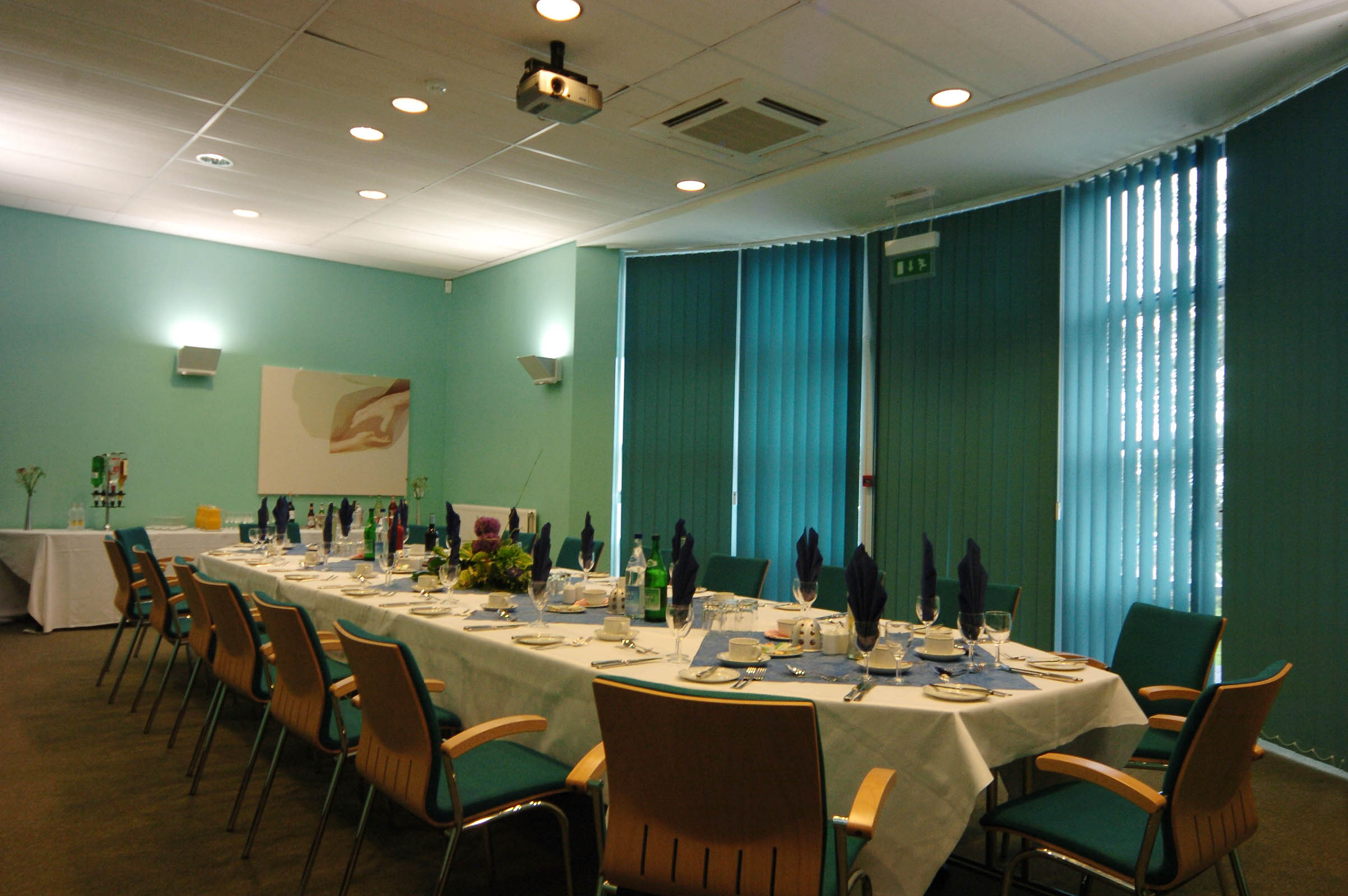 Elegant meeting room with long table set for corporate dining event in Fielder Centre.
