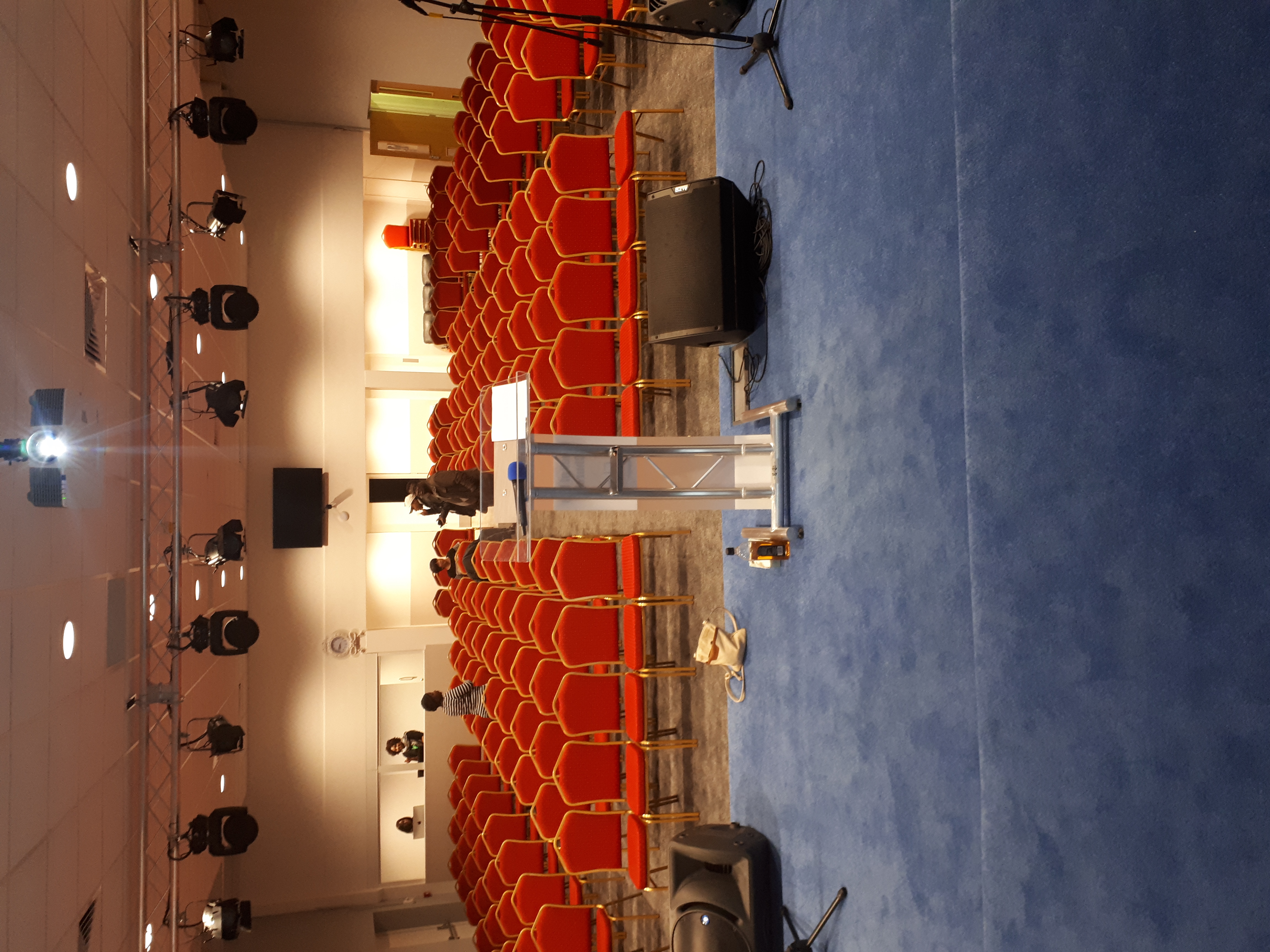 Business conference room with podium and red chairs at Elim Pentecostal Church, Harlesden.