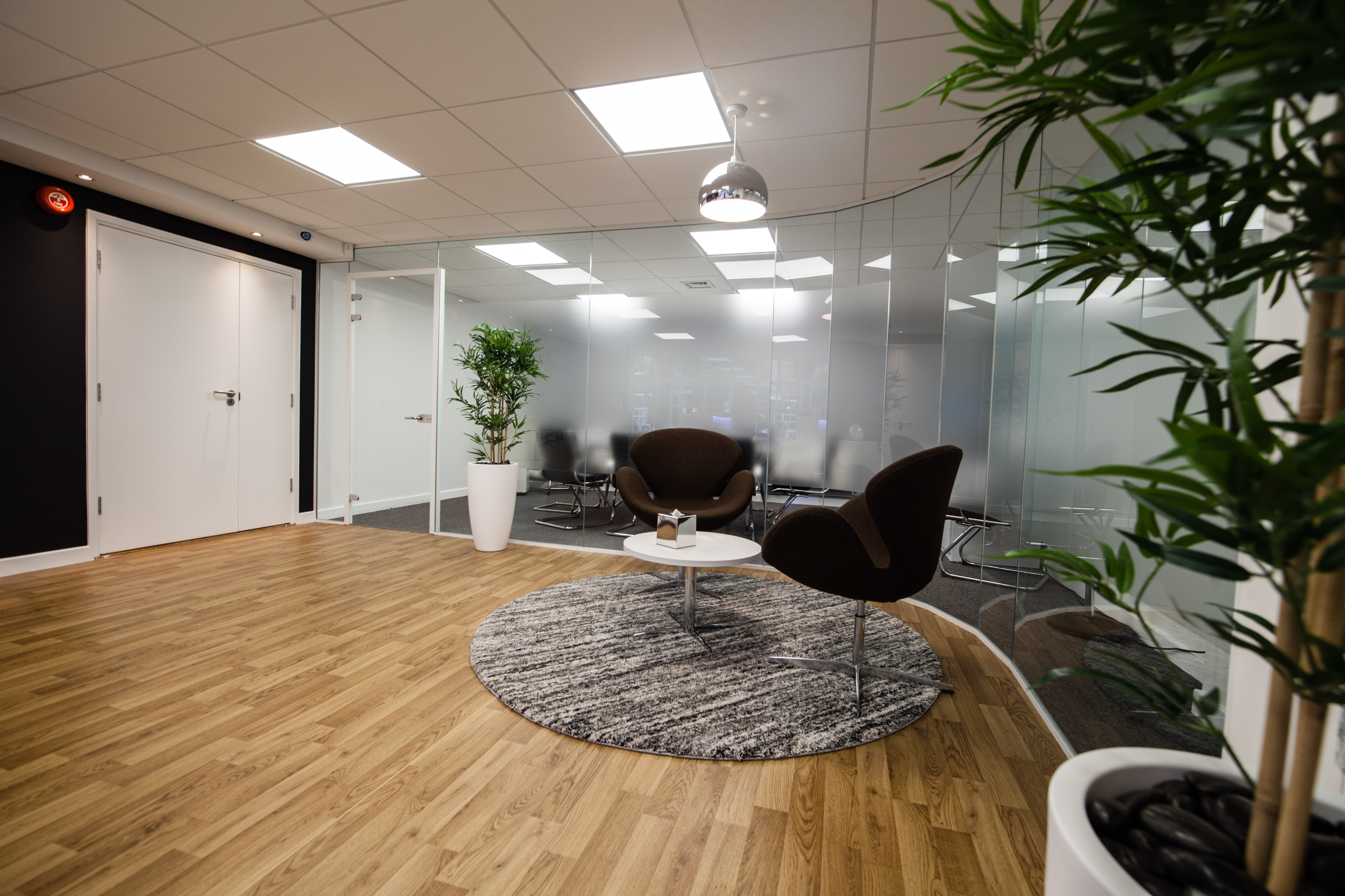 Modern meeting room with glass walls, ideal for brainstorming and casual meetings.