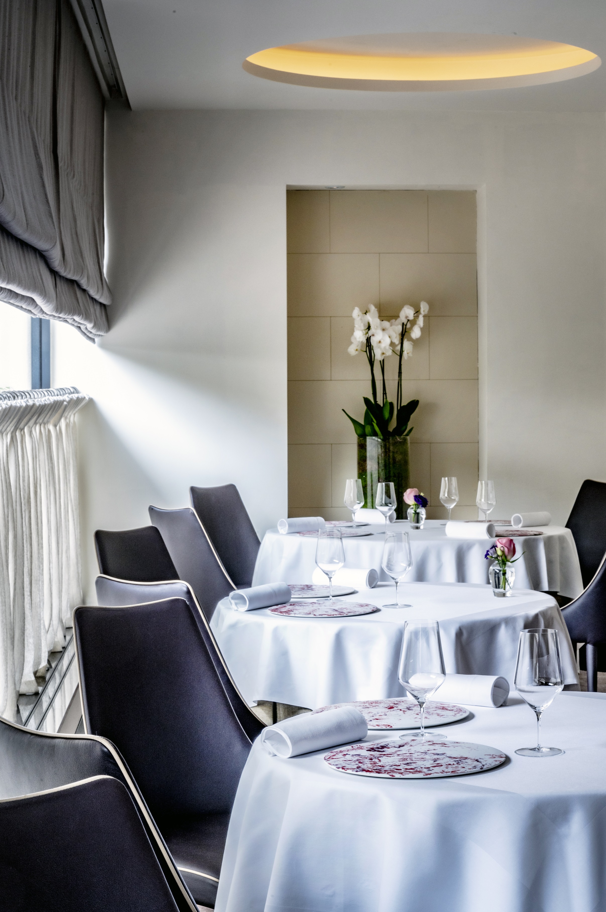 Elegant dining area with round tables for upscale events and intimate meetings.