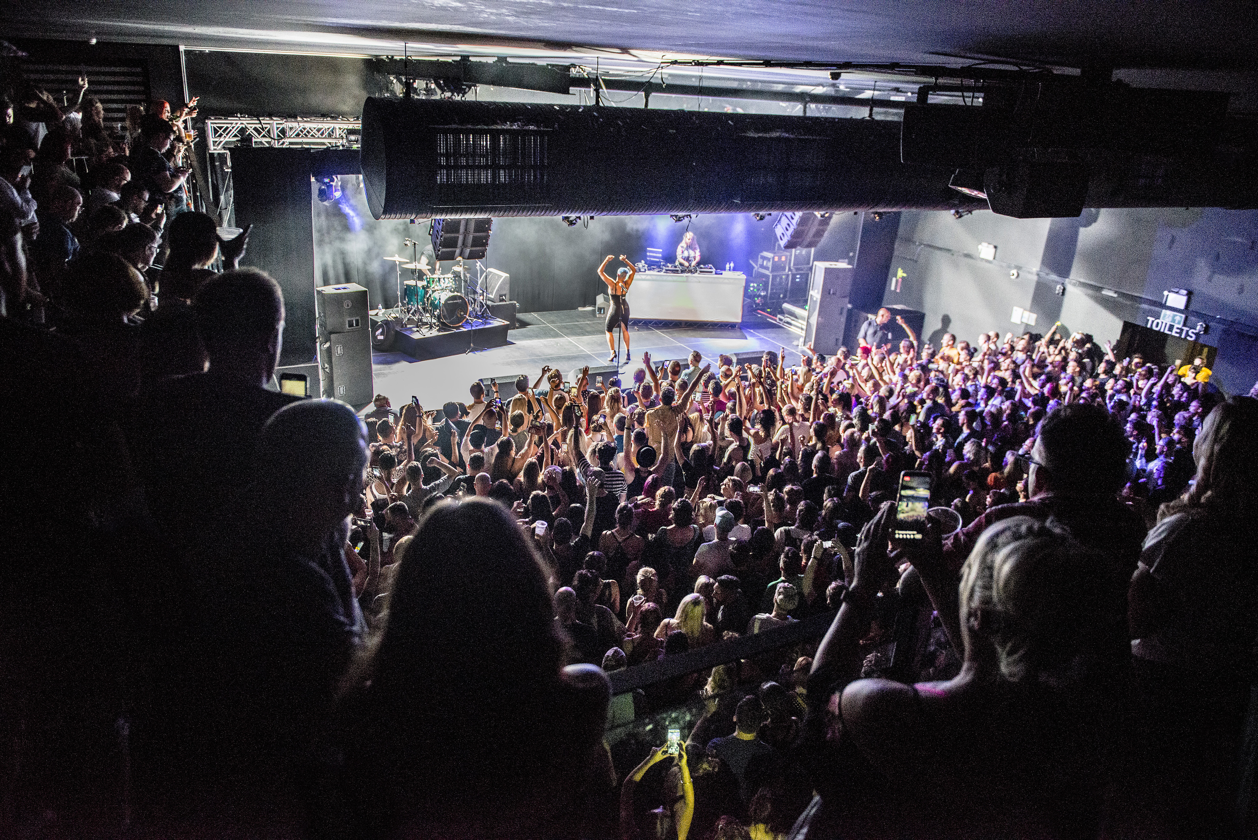 Vibrant live event in Tramshed Cardiff with engaged audience and dynamic stage setup.