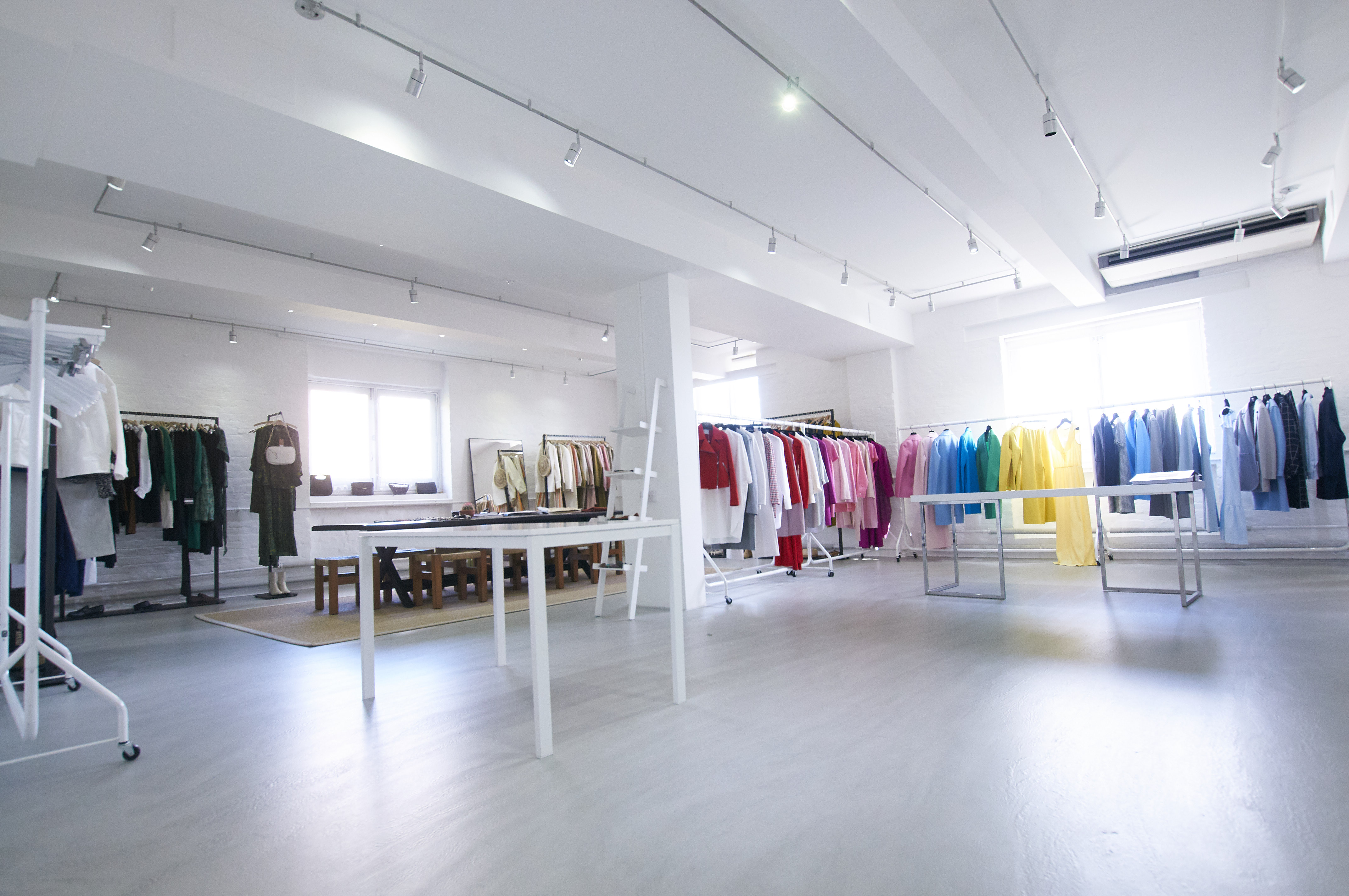 Bright, spacious showroom with organized clothing racks for fashion events and product launches.
