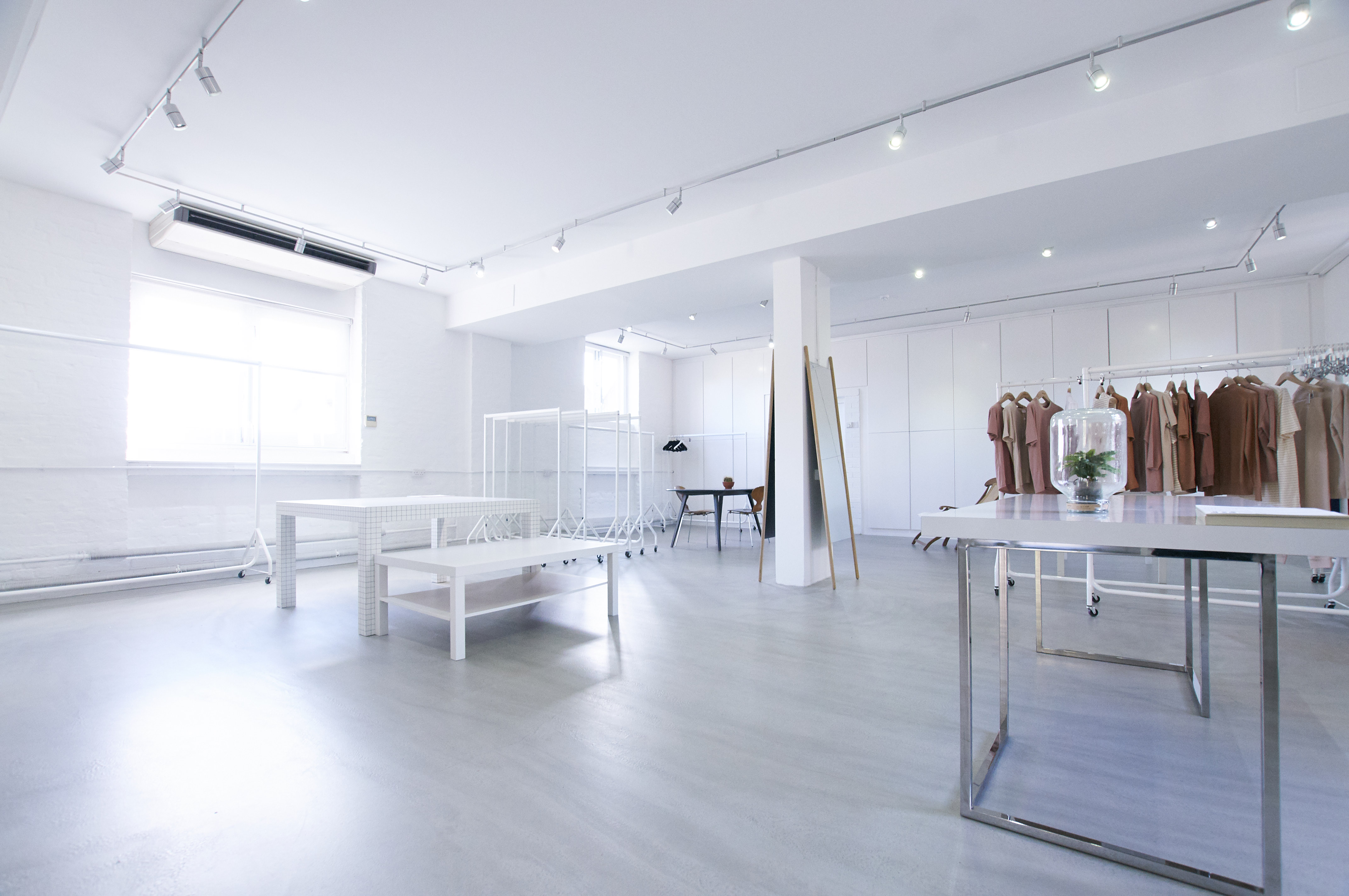 Minimalist event space with bright lighting for fashion showcases and pop-up shops.