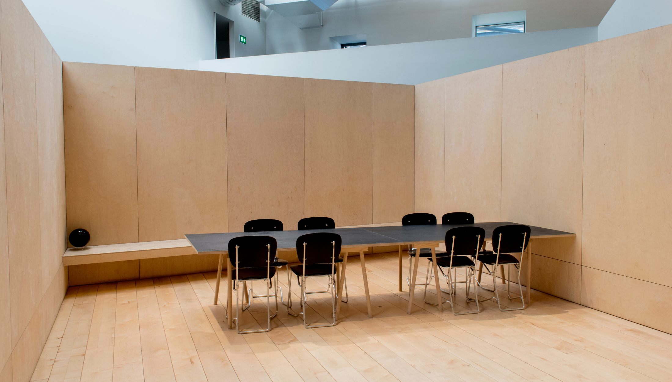 Minimalist meeting space with black table and chairs, ideal for brainstorming sessions.