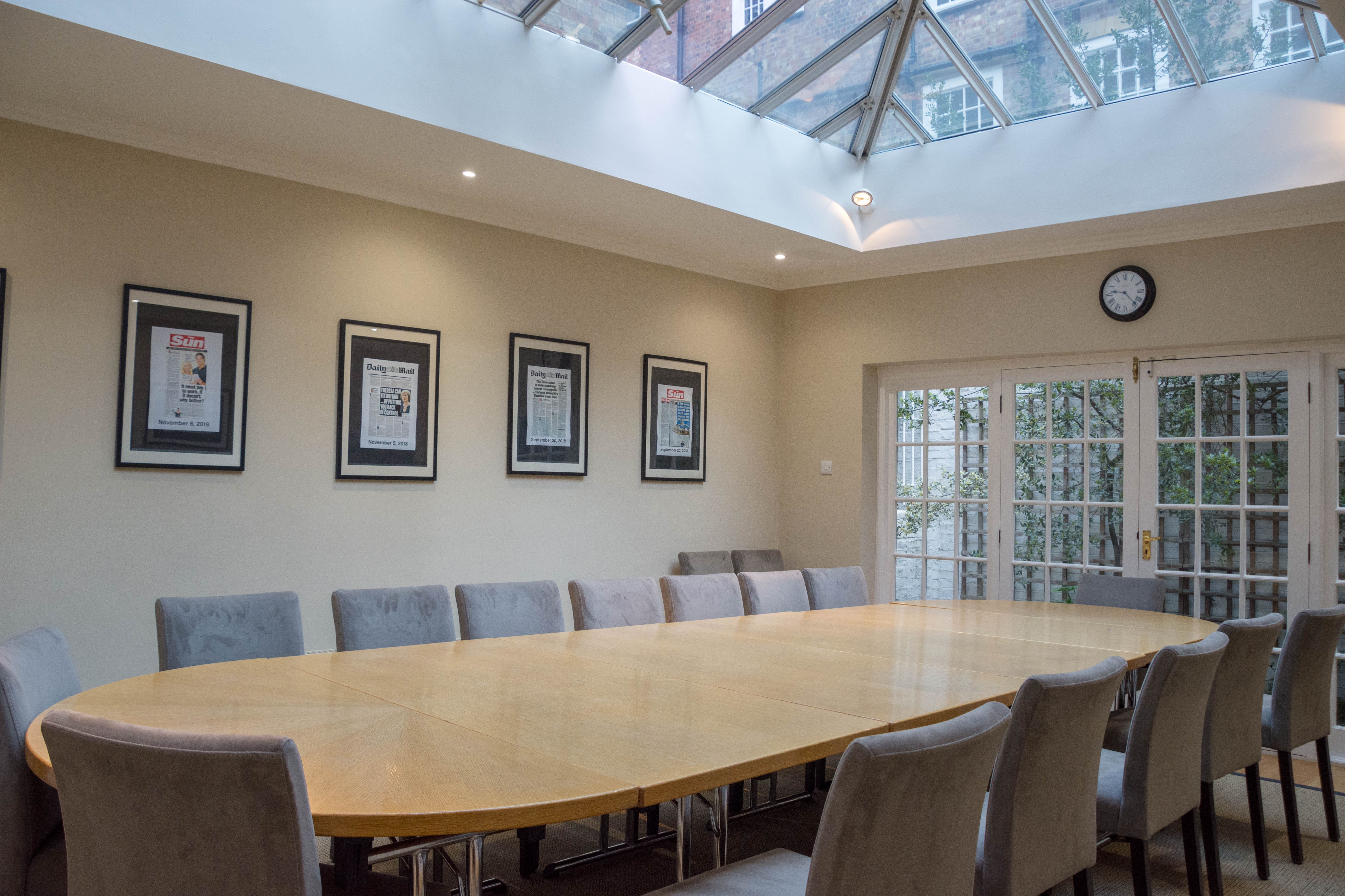 Boardroom with oval table and glass ceiling, perfect for corporate meetings and events.