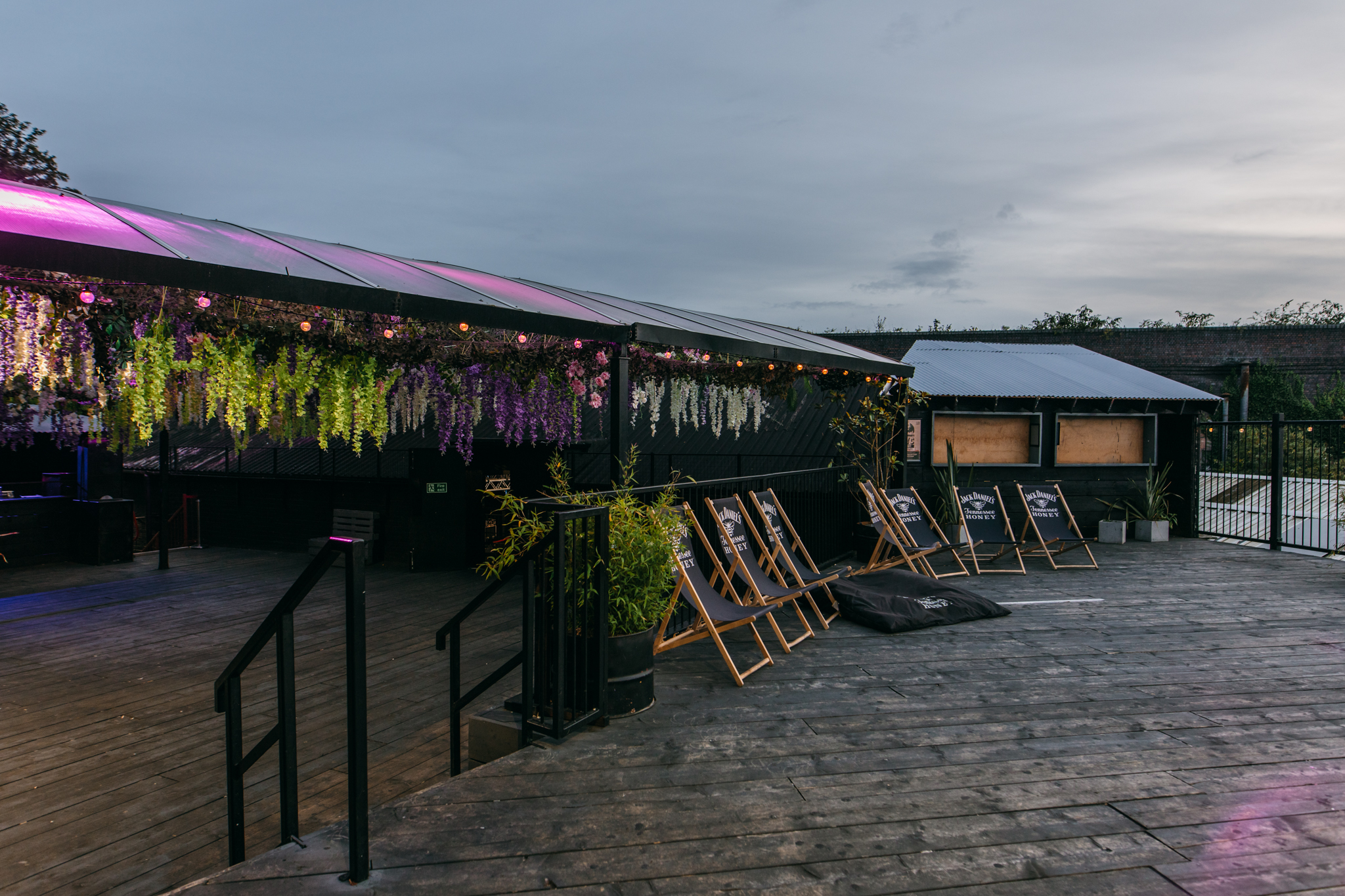 Outdoor event space at XOYO Birmingham with cozy deck chairs and vibrant floral decor.