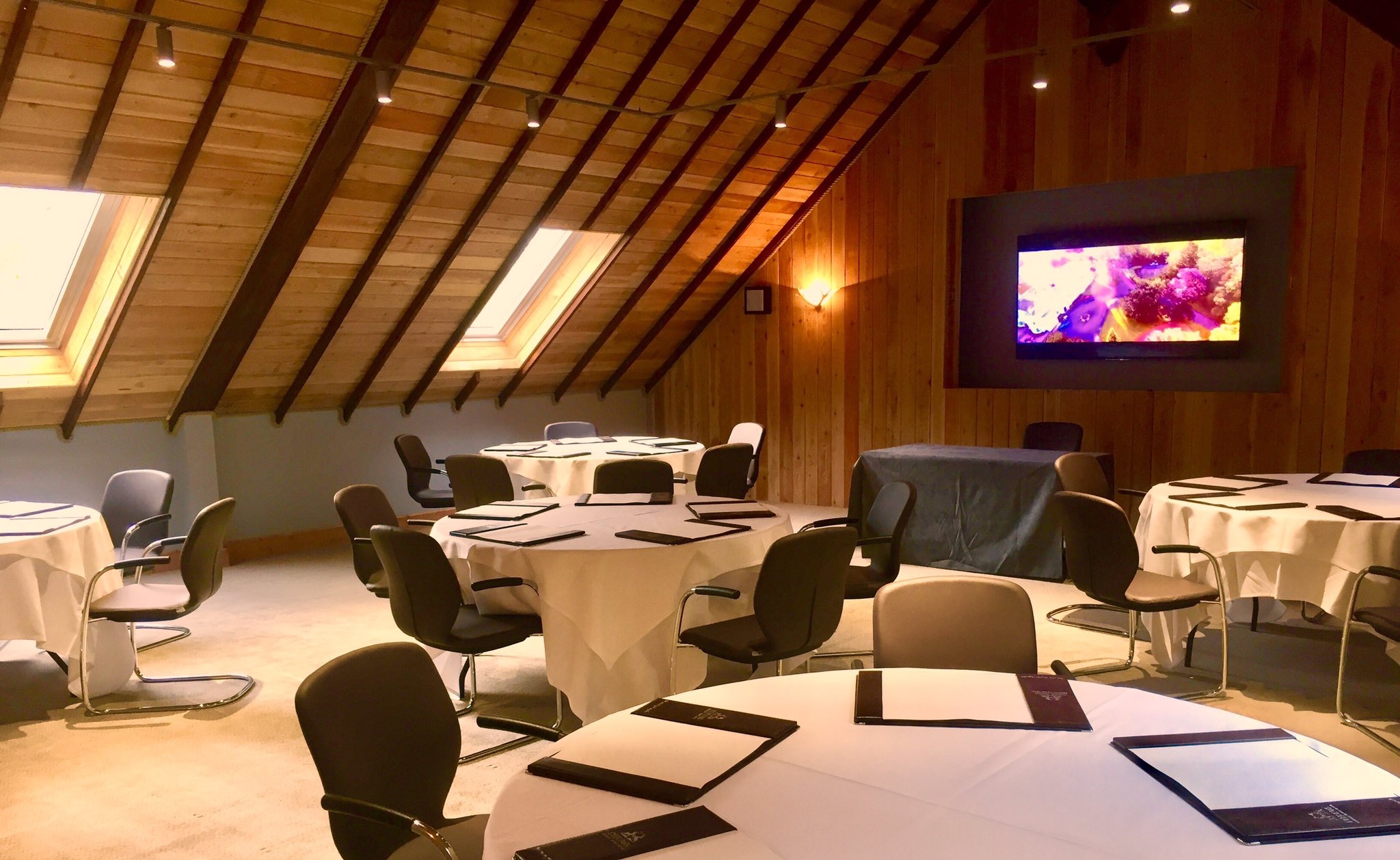 Motor House Meeting Room with round tables, ideal for workshops and conferences.