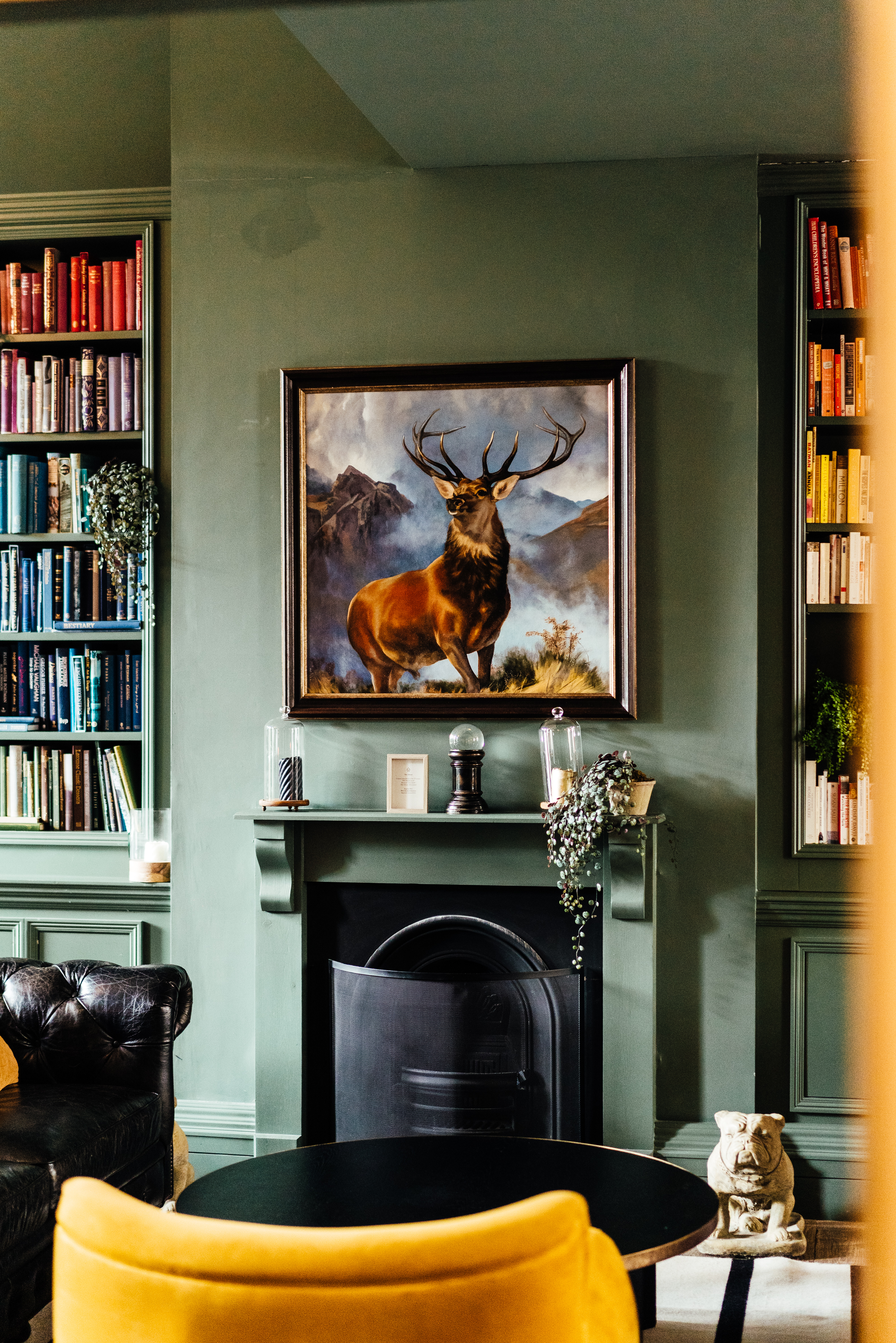 Elegant fireplace and stag painting at Kindred's Library venue for intimate events.