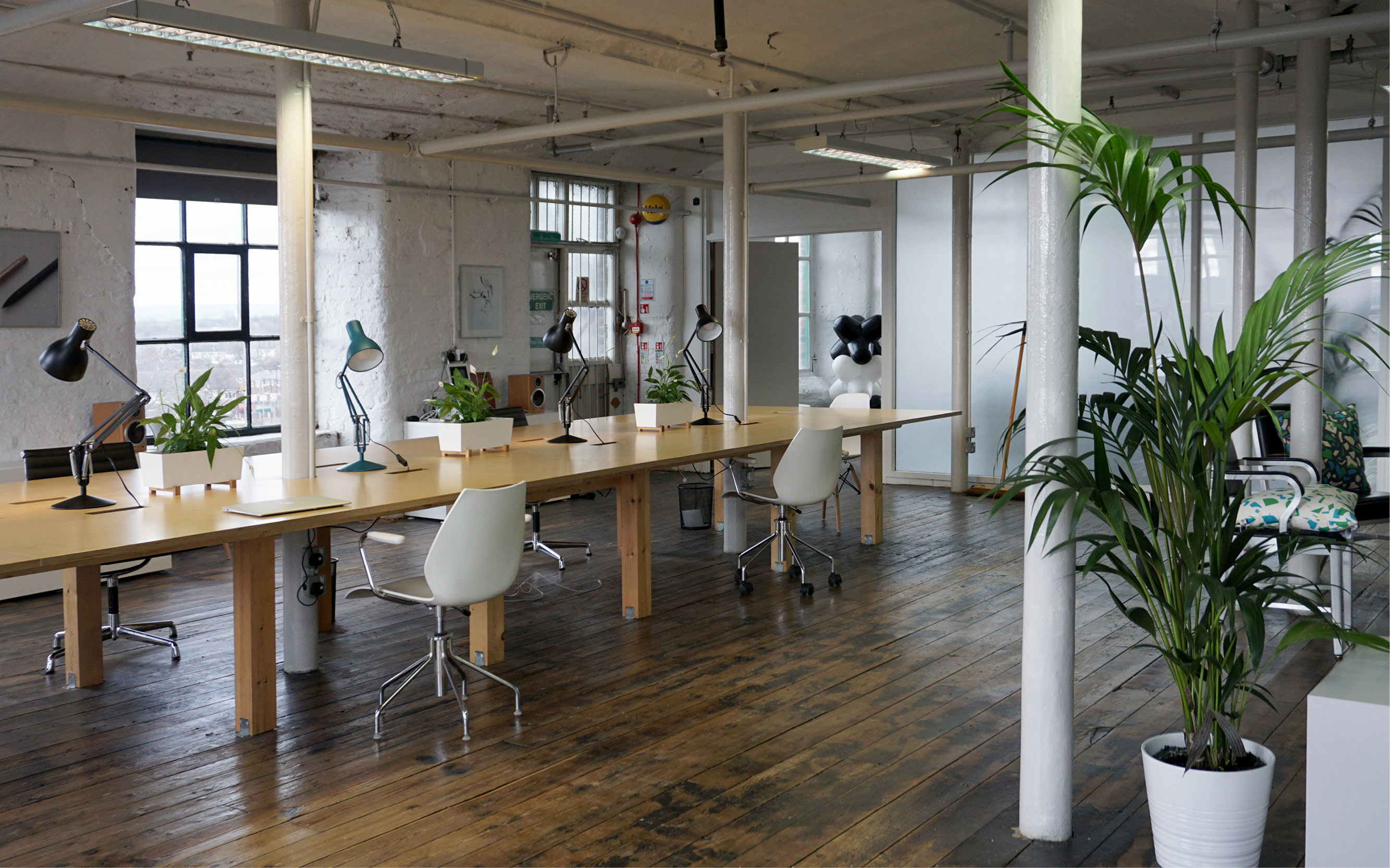 Modern open workspace with wooden table, ideal for meetings and brainstorming sessions.