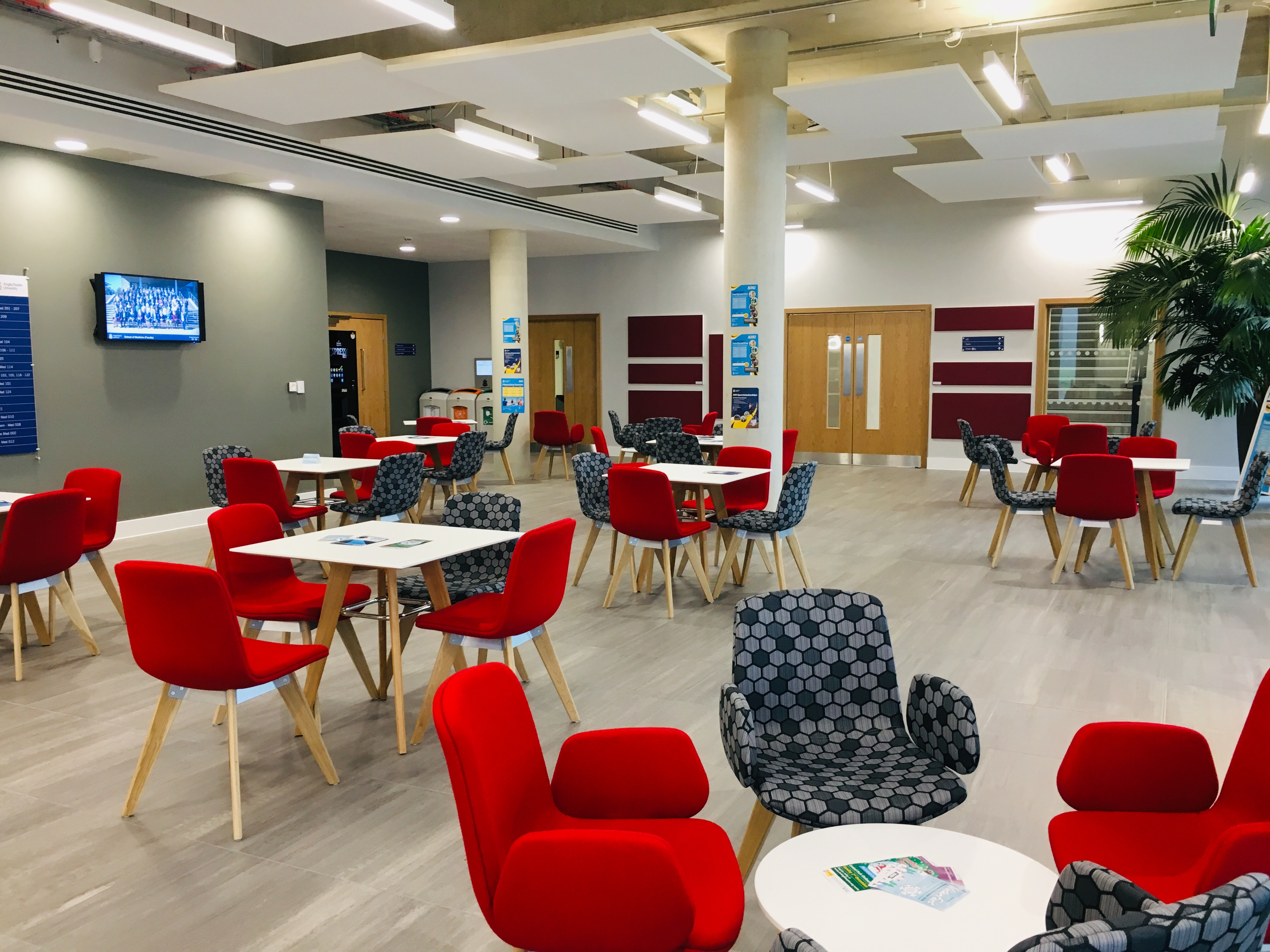 Modern meeting space with red chairs, ideal for networking and events in Chelmsford.